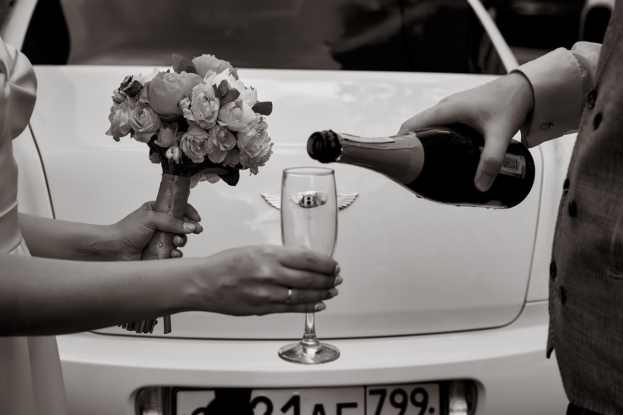 жених наливает в бокал шампанское невесте на фоне бентли  Свадебная фотосъемка в Москве. Свадебный фотограф в Москве  Сергей Гаварос.