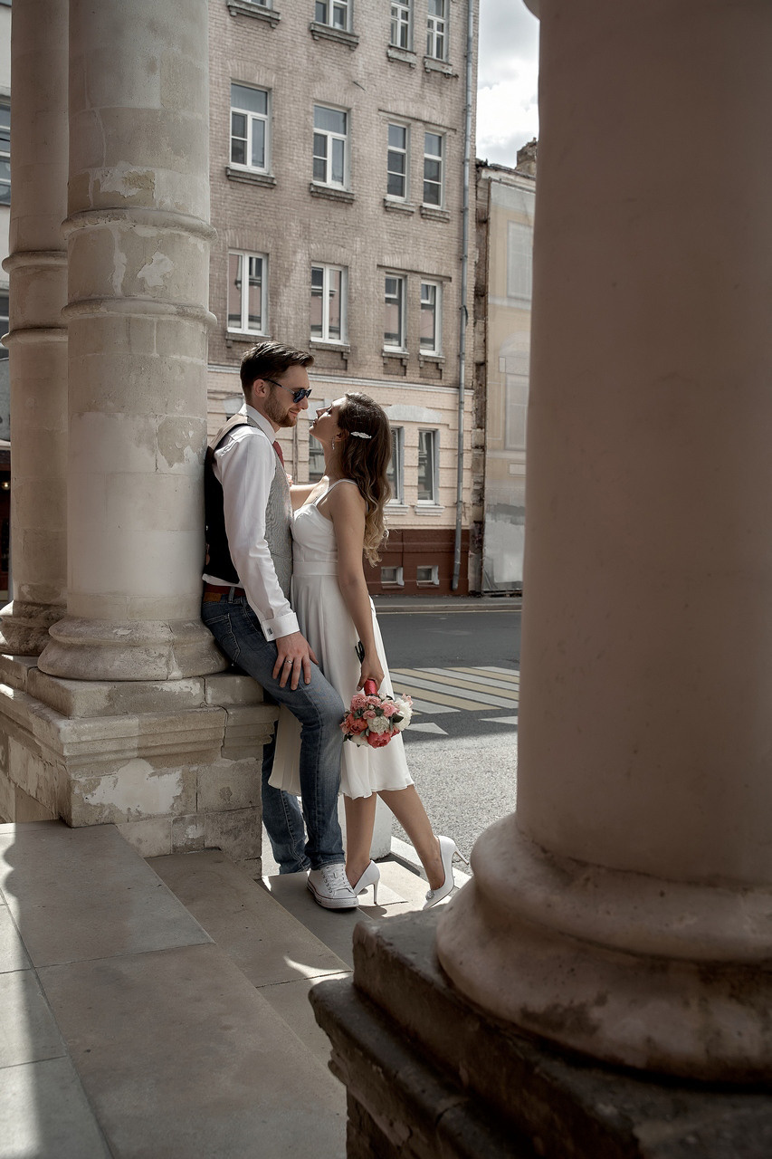 объятия молодоженов возле колонны Свадебная фотосъемка в Москве. Свадебный фотограф в Москве  Сергей Гаварос.