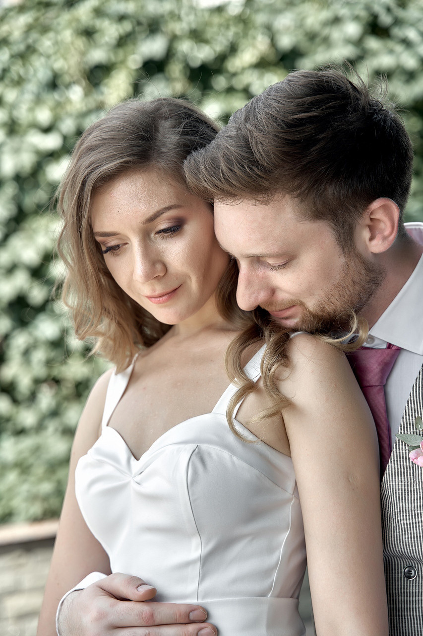 Жених обняв невесту сзади целует ей плечо. Свадебная фотосъемка в Москве. Свадебный фотограф в Москве  Сергей Гаварос.