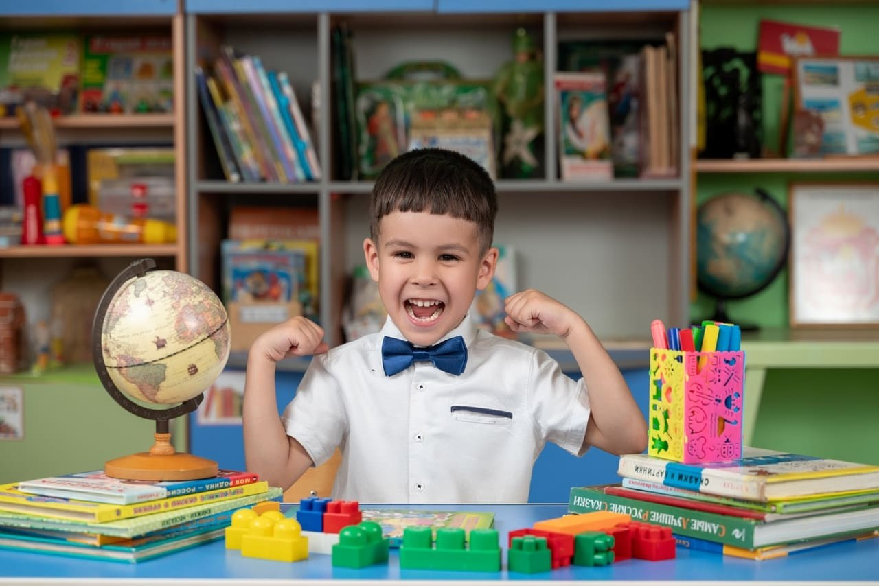 Смешливый парень позирует фотографу в детском саду.