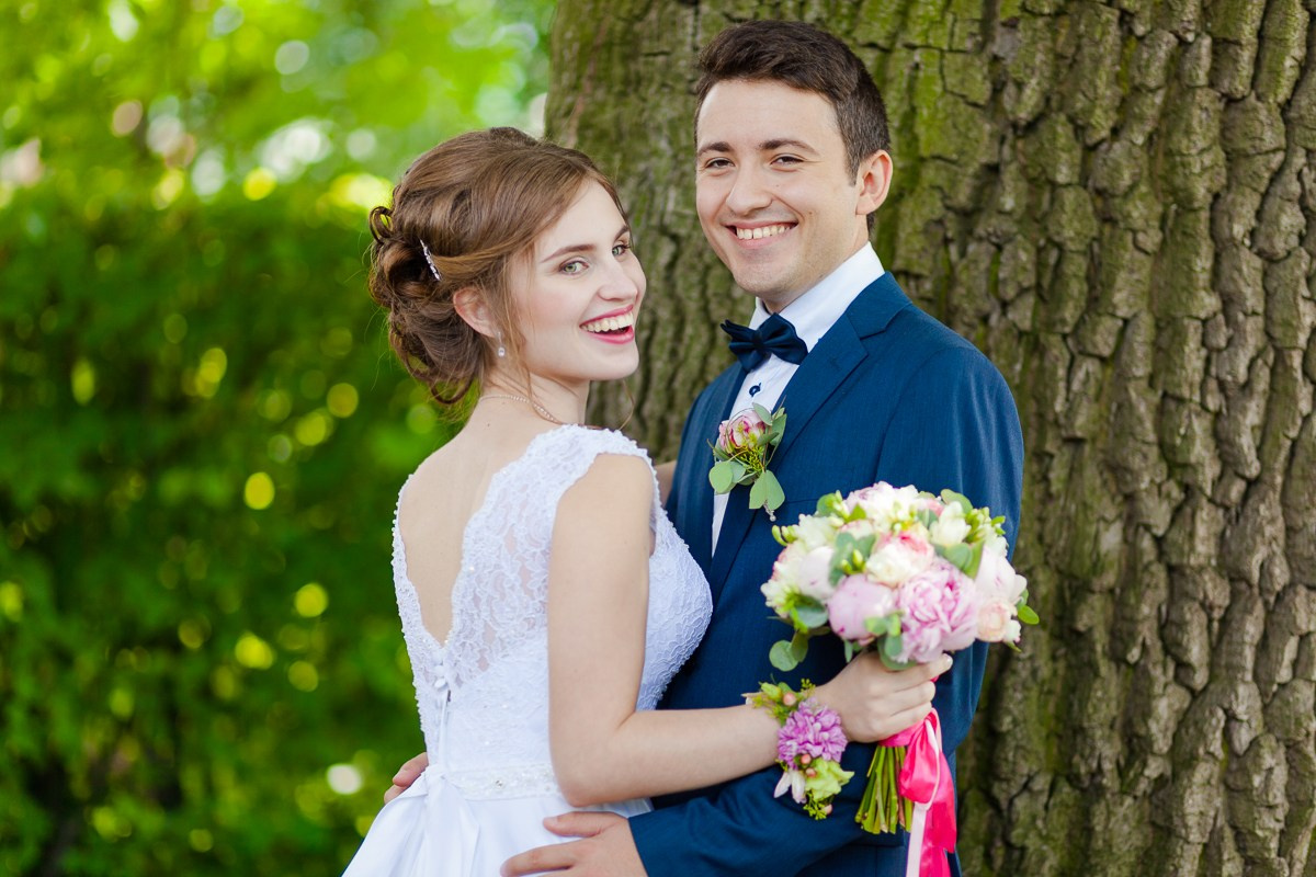 Молодожёны улыбаются смотря в камеру на фотосессии