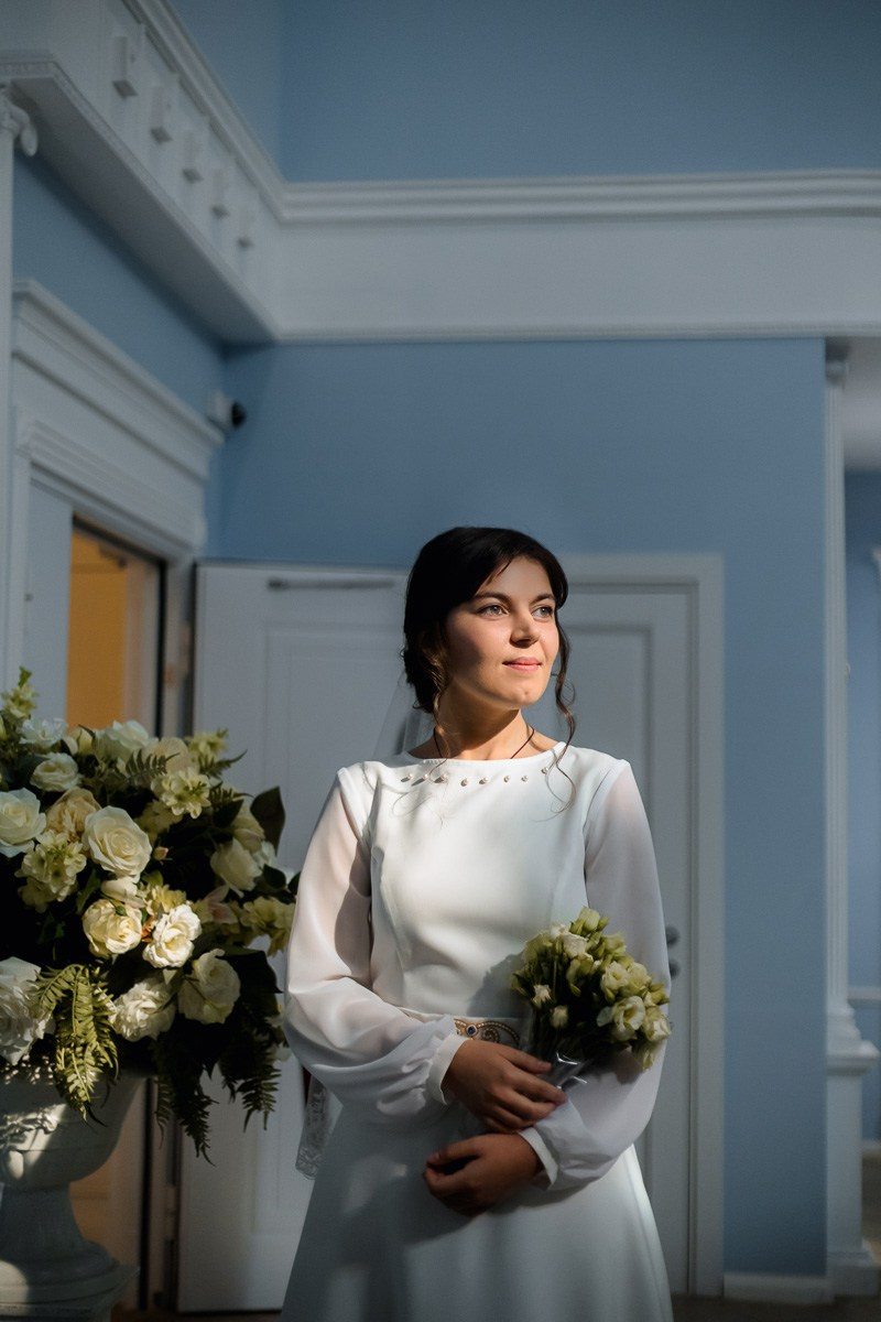 Невеста стоит на лестнице в холе ЗАГСа Красносельского района Санкт-Петербурга