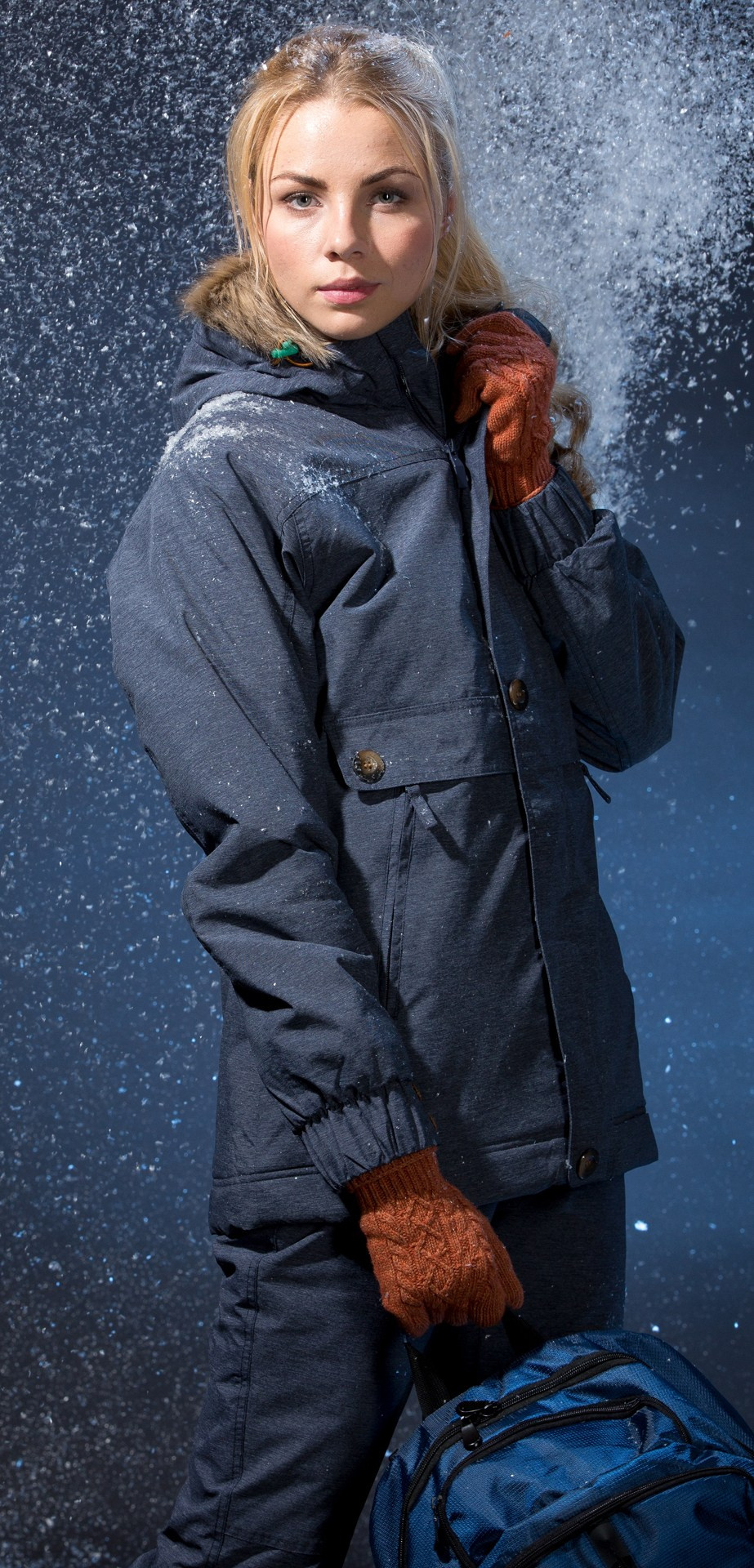 девушка в зимней одежде от guahoo под снегом в студии