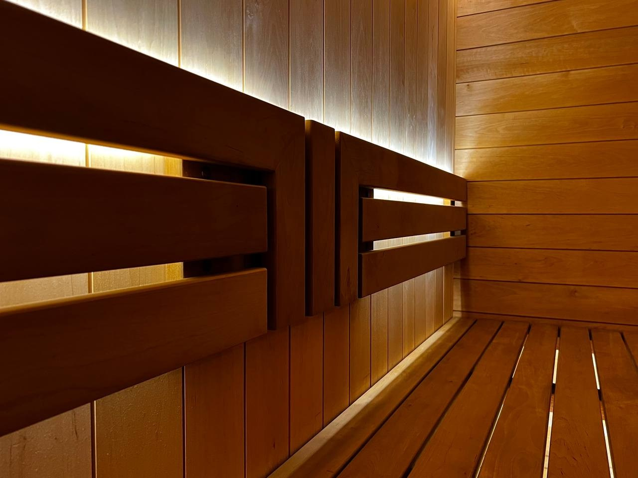 Уютная сауна в КП Новый Мир. В центре внимания- Harvia Cilindro, а закарнизное освещение плавно перетекает в подсветку противопожарного угла. SaunaTopMasters