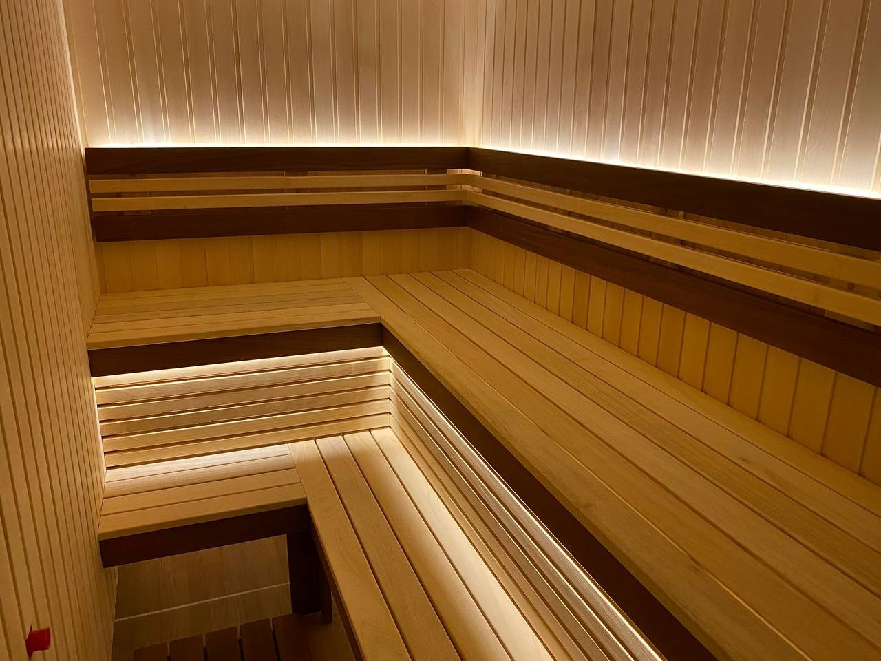 Семейная сауна в Кузьмолово на базе Harvia Glow. В отделку из липы встроены просторные полки из комбинации абаши+ термоабаши. SaunaTopMasters