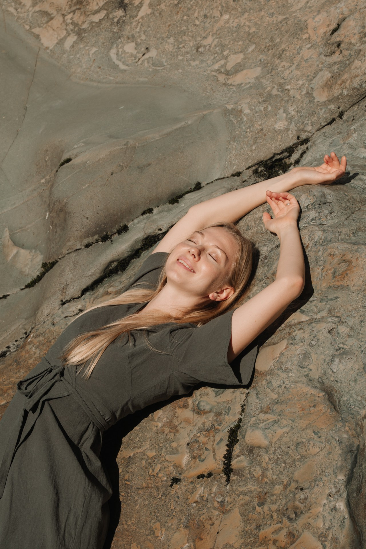 Фотоснимок девушки лежит на камне 