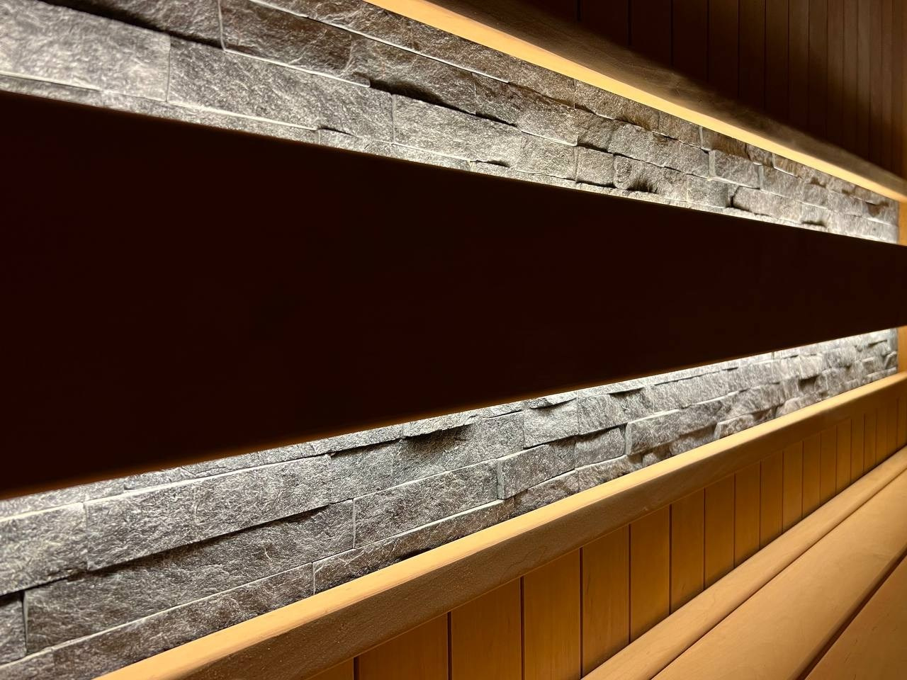 Семейная сауна в Охте: термоольха, природный камень и аккуратное реечное ограждение печи, защищающее любопытные детские ручки. SaunaTopMasters