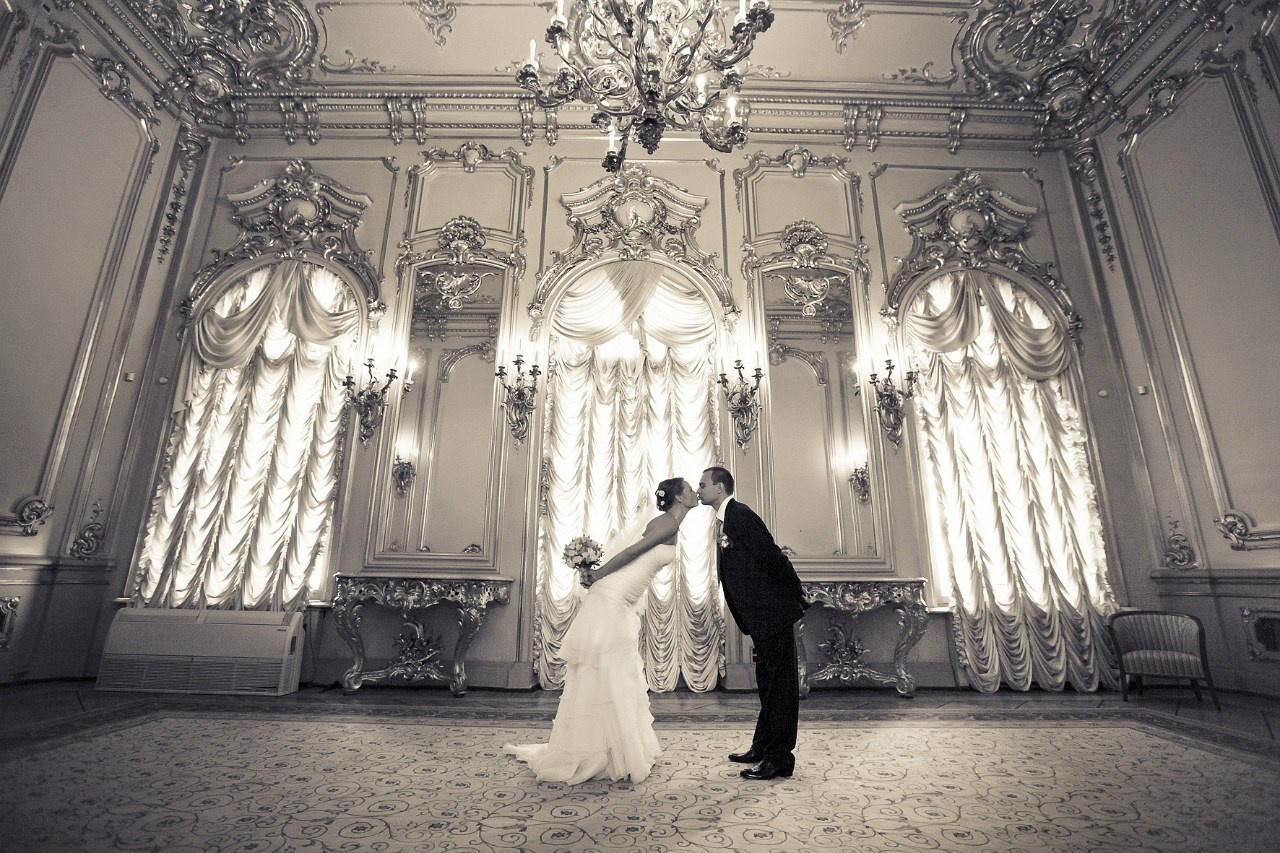 молодожены имитируют фигурки на торте целуясь во дворце бракосочетания 