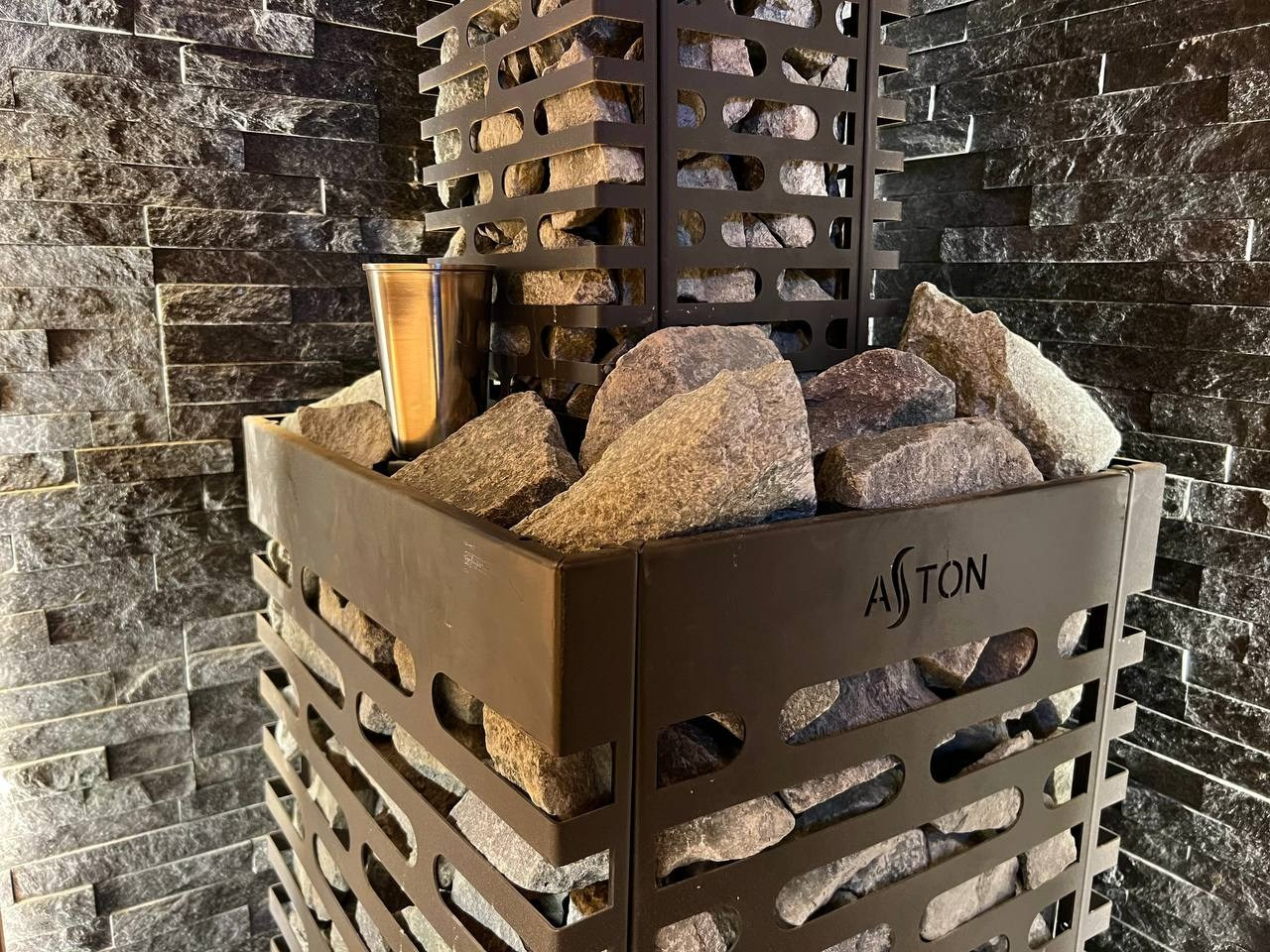 Семейная баня в Рощино из ольхи с можжевеловым панно, яркой печной зоной, закарнизной подсветкой и печью от производителя Aston. SaunaTopMasters