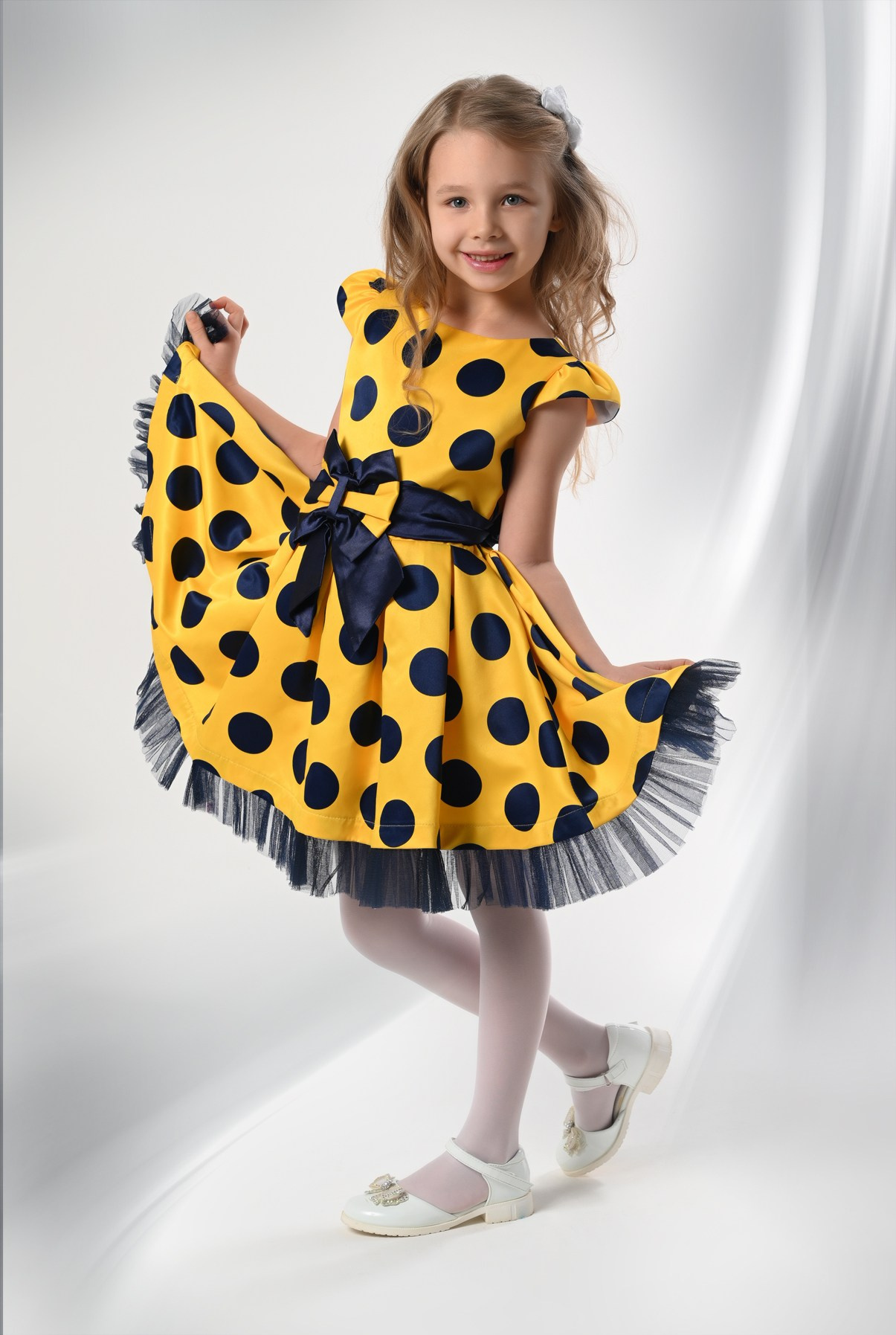 Девочка в жёлтом платье в горошек в фотостудии