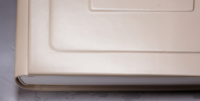 Детальный макроснимок фактуры материала обложки фотокниги. Демонстрация идеального шва и мягкого матового блеска премиальной кожи.