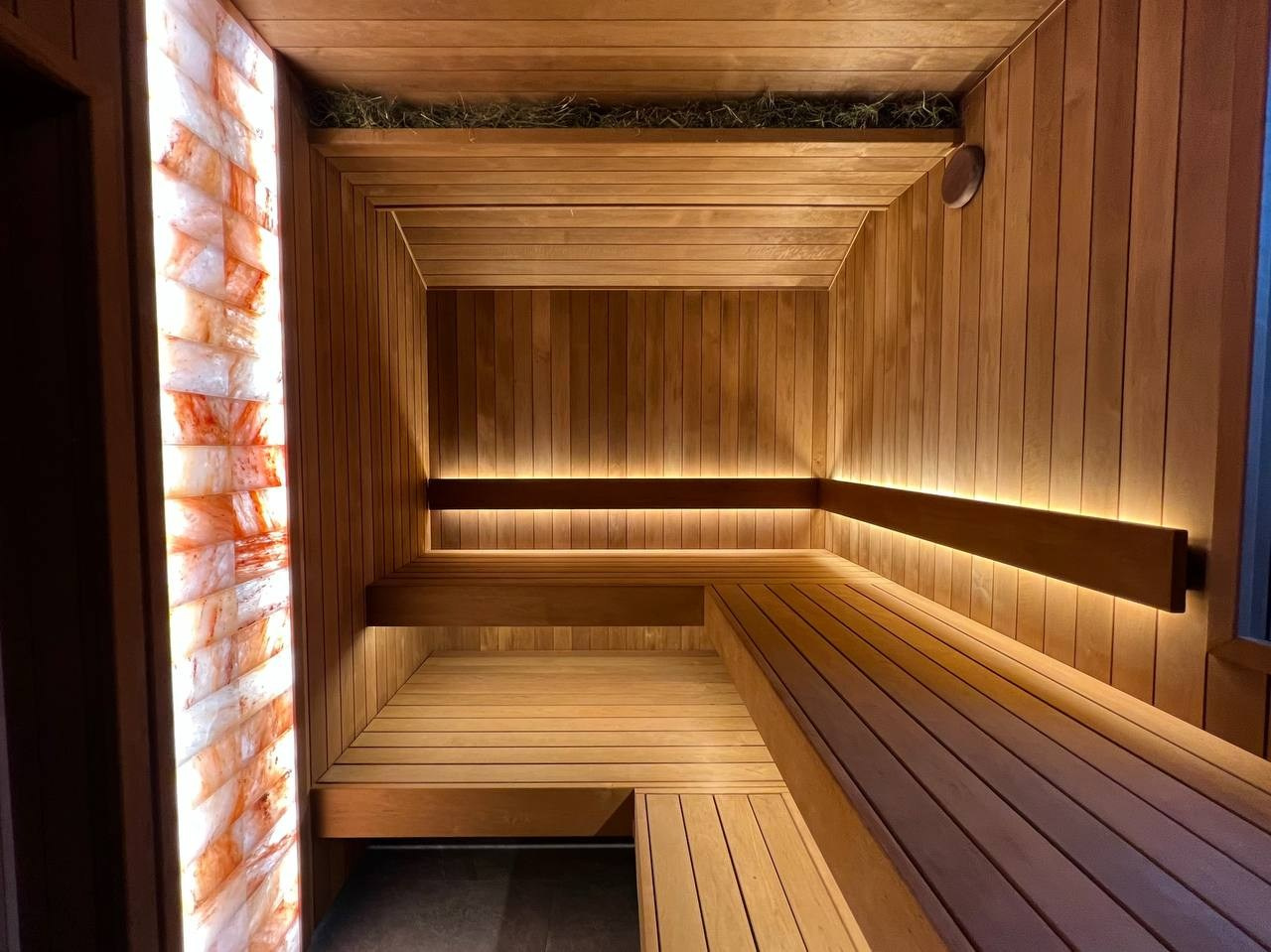 Атмосферная парная в Садах Времени с большим панно из гиммалайской соли, сеном с горных лугов Крыма и теплой линейной подсветкой. SaunaTopMasters