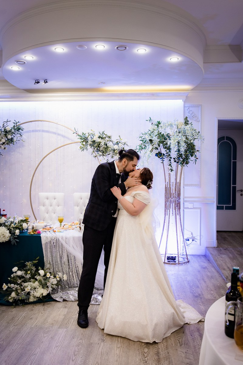 Жених и невеста целуются в ресторане Санкт-Петербурга. Вертикальный кадр.