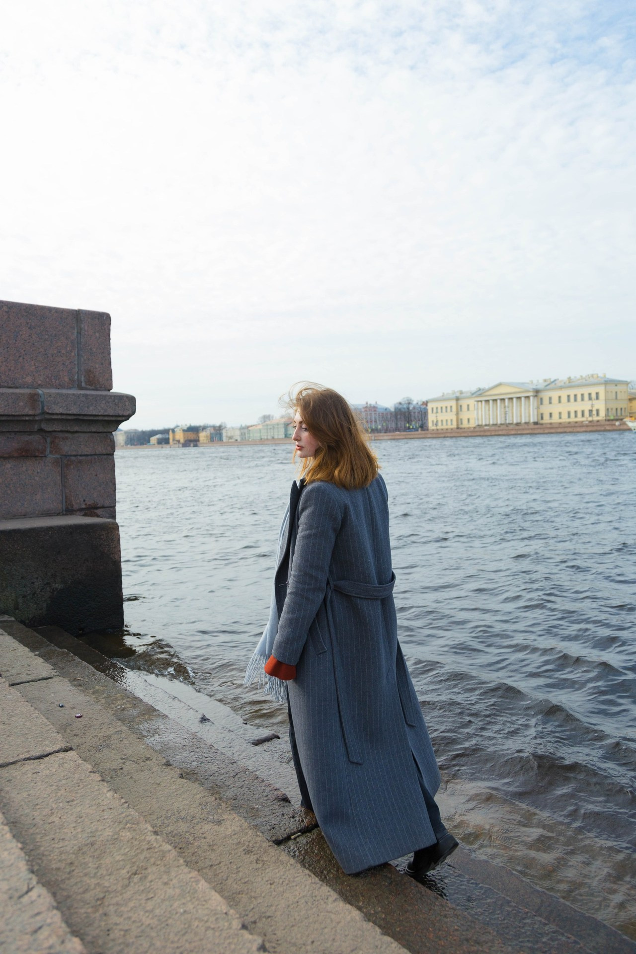 Прогулочная фотосессия на набережной Невы в Санкт-Петербурге: девушка позирует на фоне воды и города 