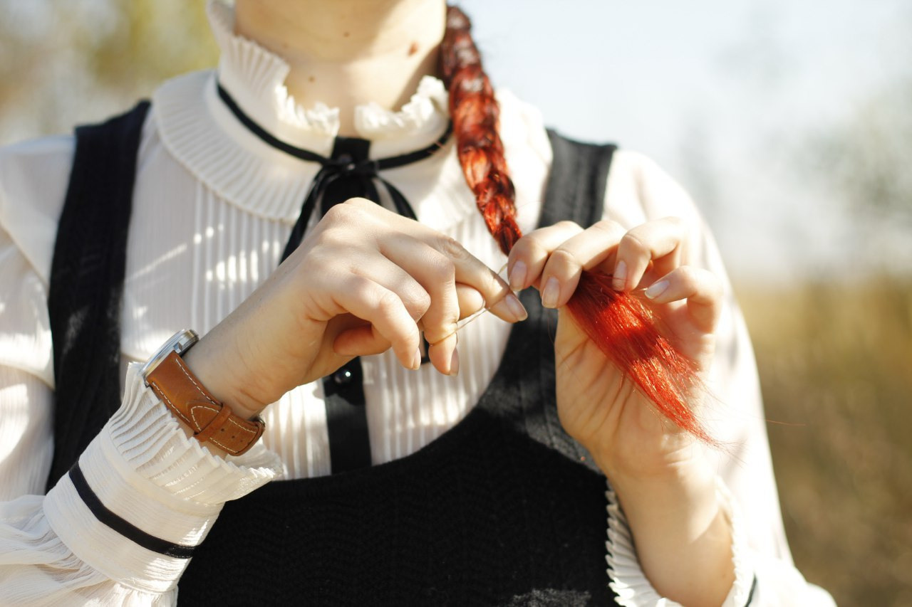 Redhead woman braids a pigtail