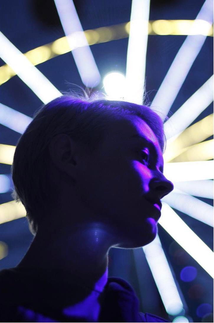 Woman and a glowing ferris wheel by Anna Karamurzina