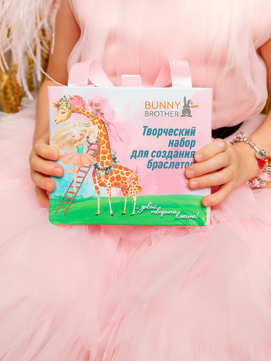 В руках девочки коробка с набором для детского творчества.