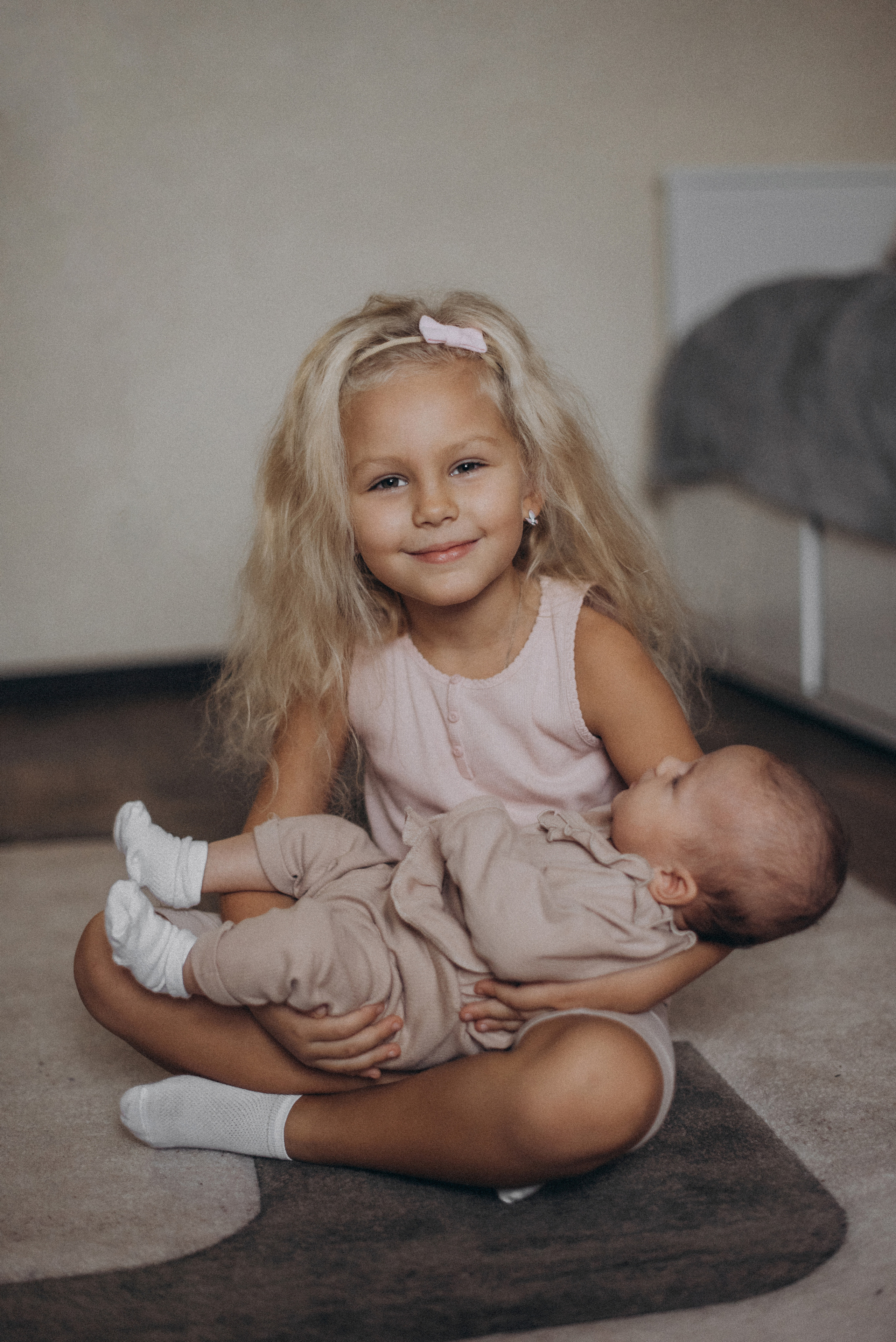 Девочка лежит на руках у старшей сестры