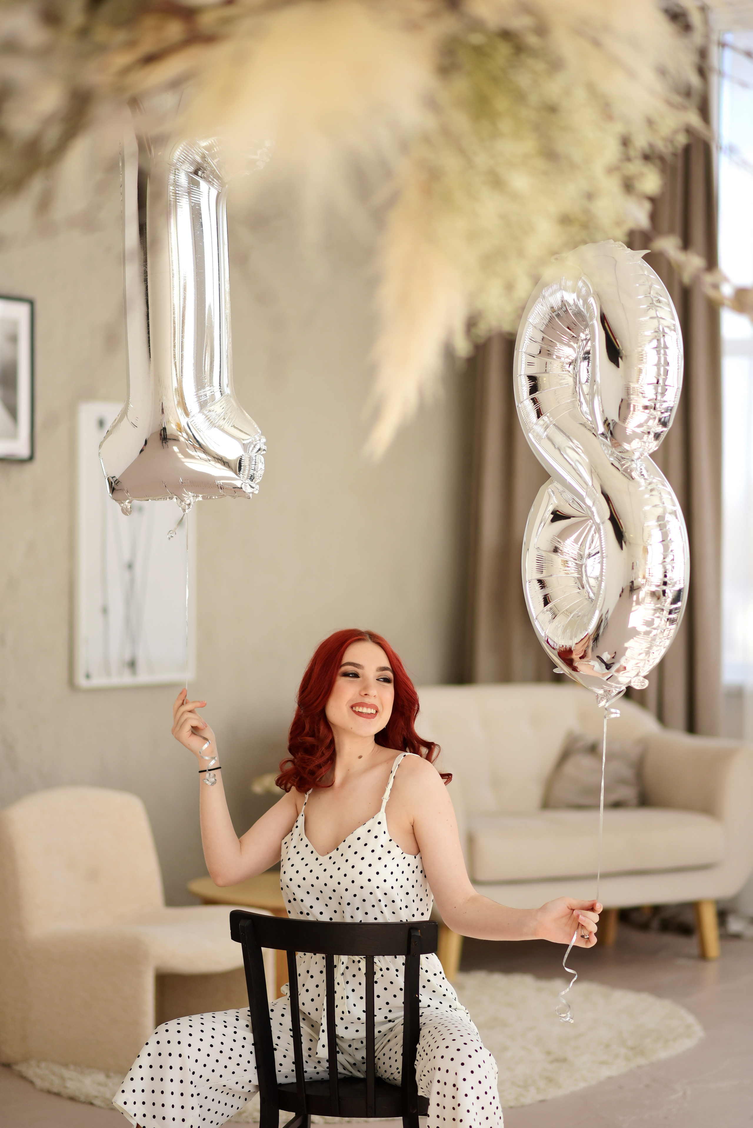 Девушка в белом комбинизоне с шираками в форме цифр в руках.