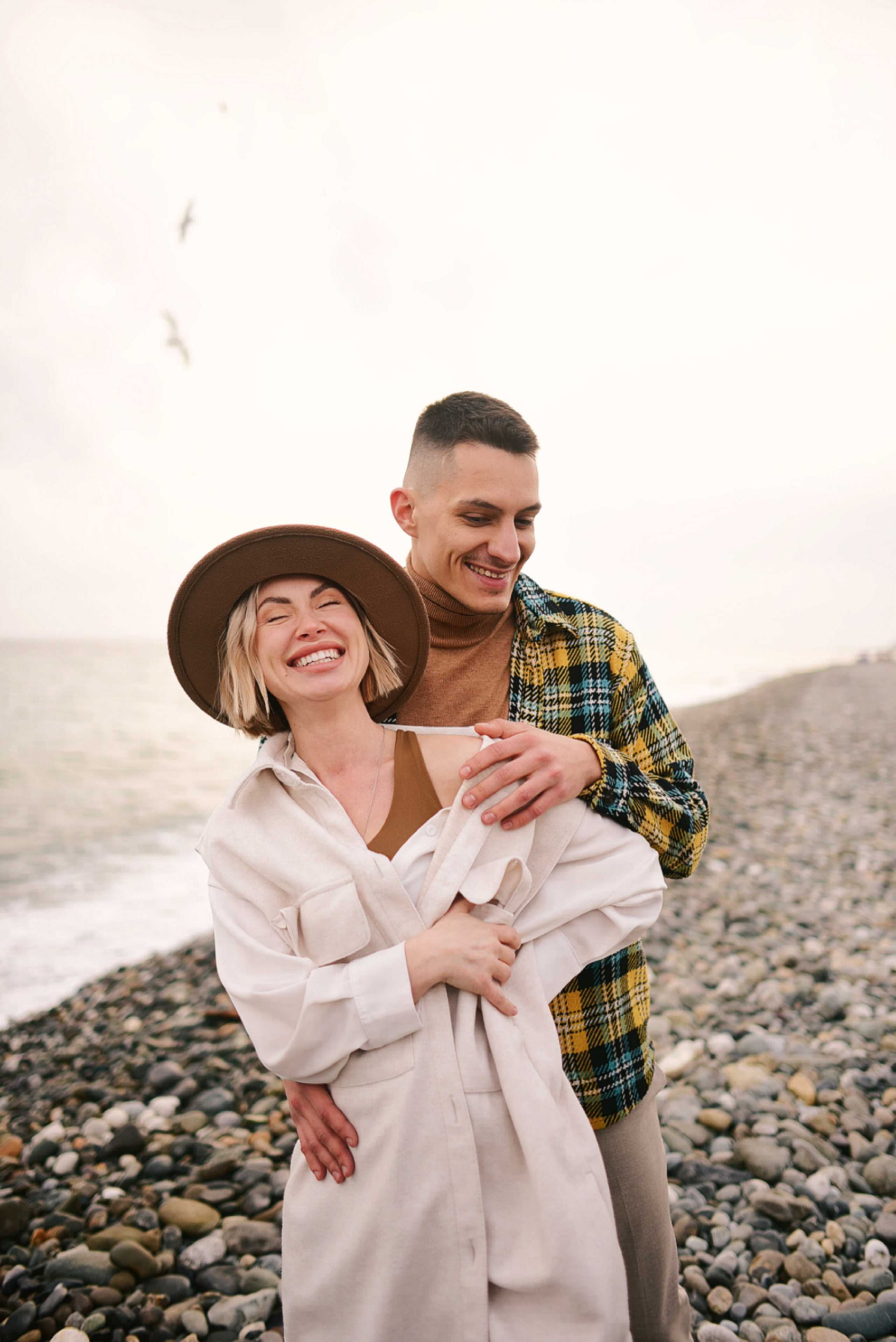 Пара на каменном берегу у моря.