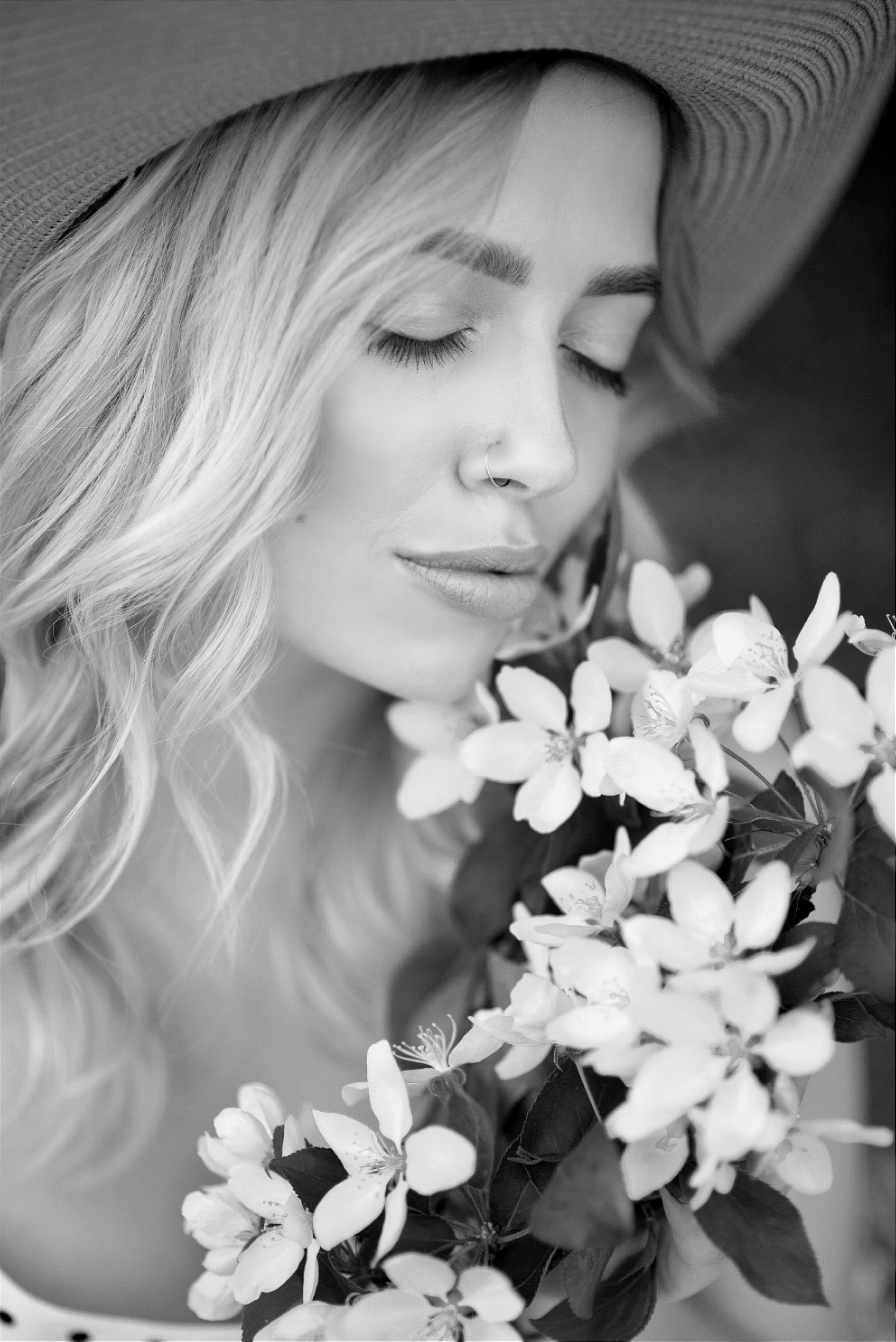 Девушка у цветущей яблони в черно-белом цвете.