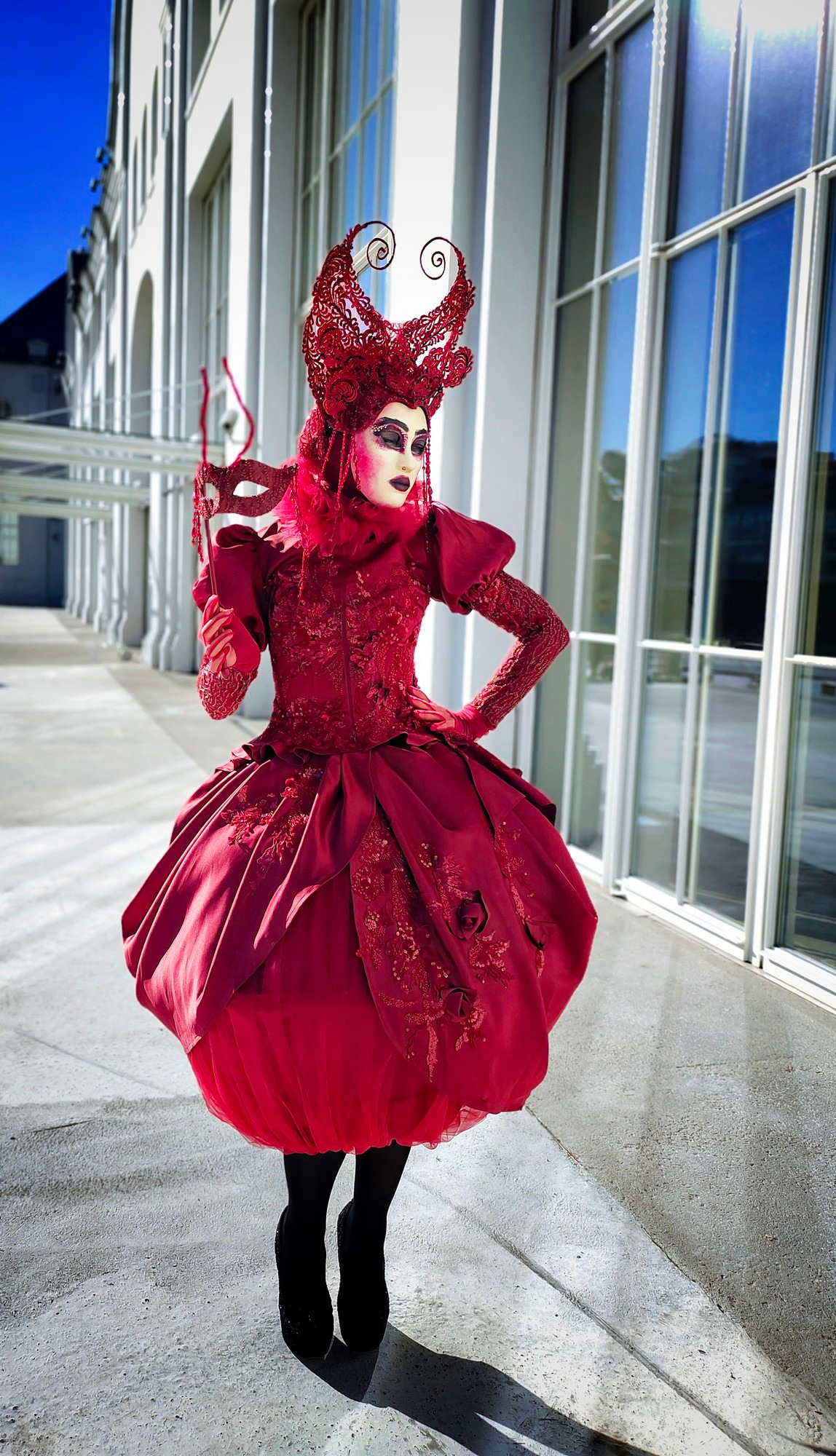 Куколка в рост взрослого человека стоит у белого каменного здания.