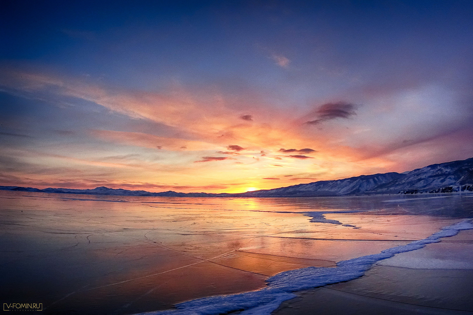 Голубой гладкий лед на Байкале с трещинами