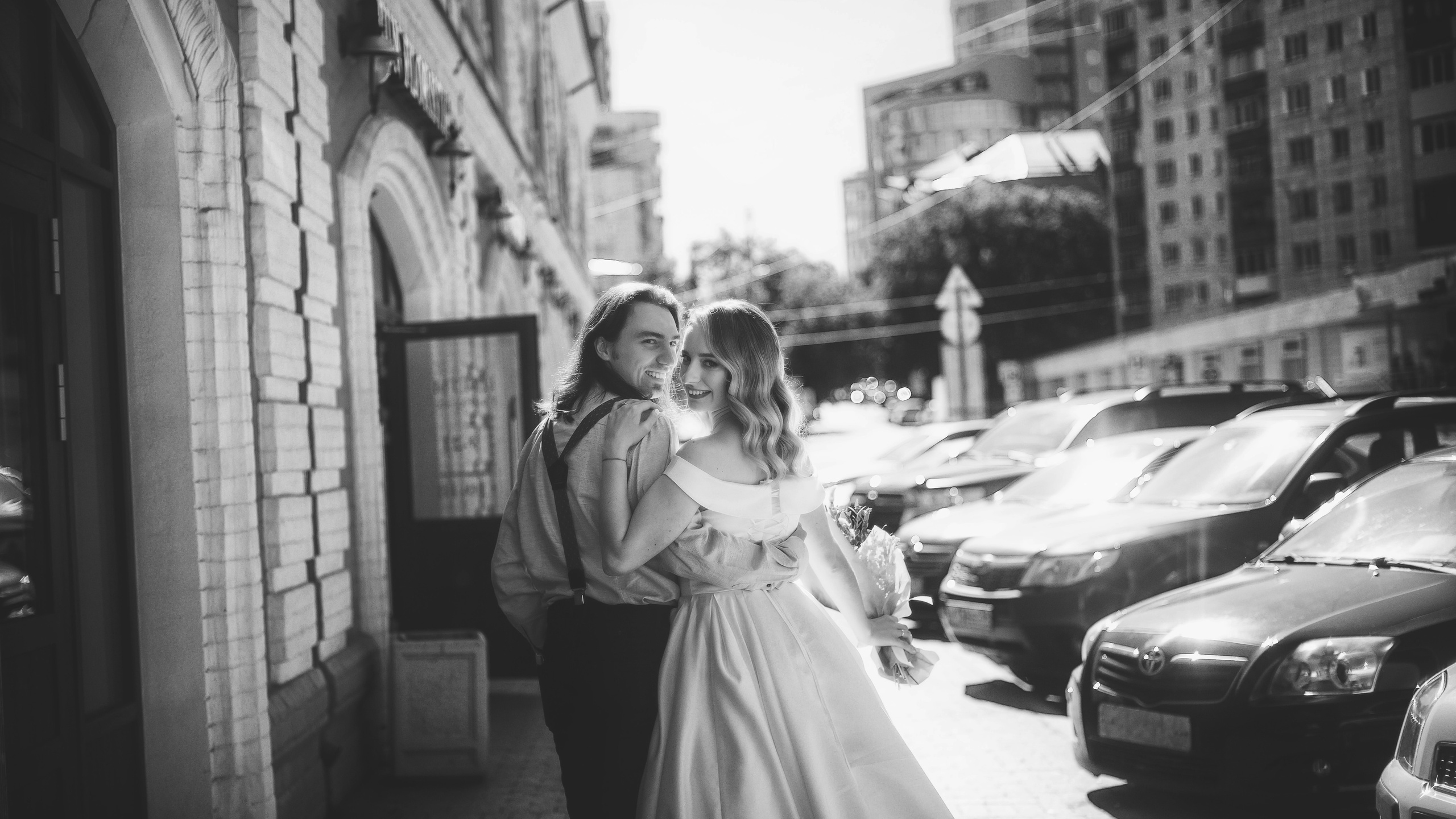 Черно-белая фотография пары молодоженов на городской улице днем