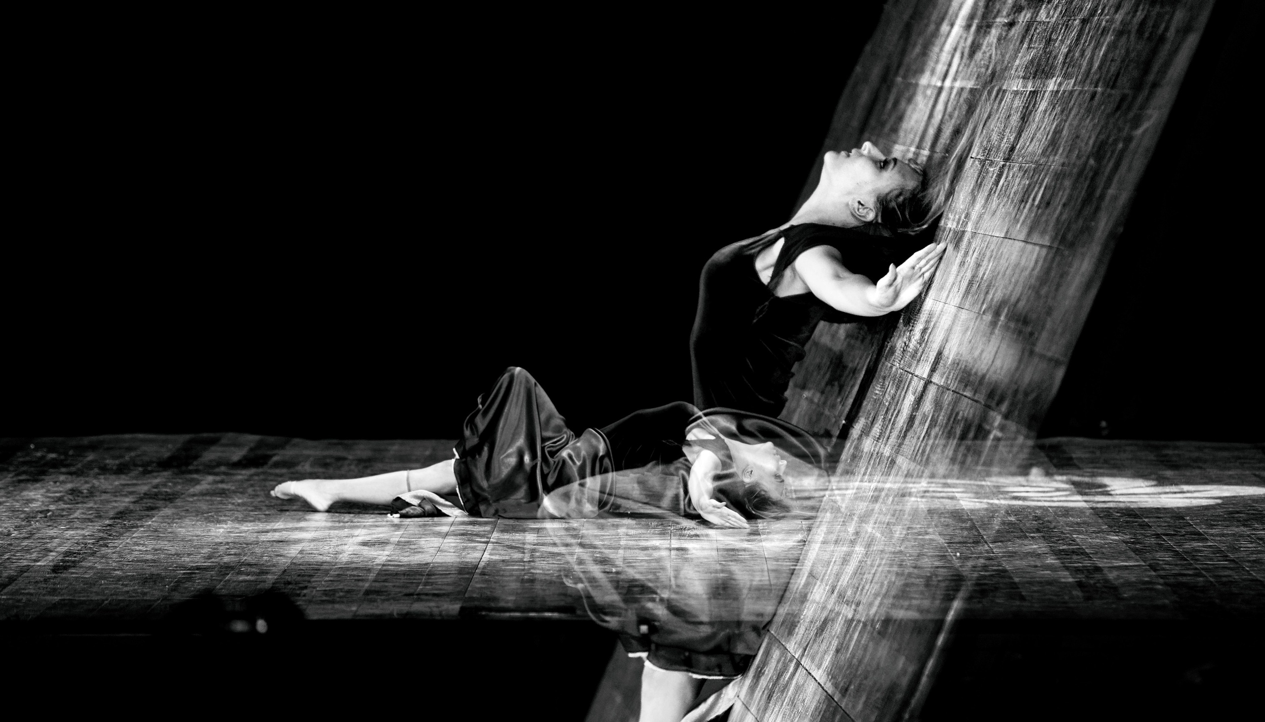 Два танцора с эффектом потока воды или света, один лежит на полу, другой тянется вверх, динамичная композиция