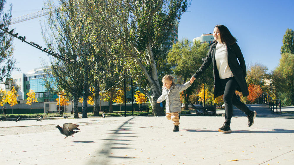 Мама с дочкой гуляют в осеннем парке в Симферополе.