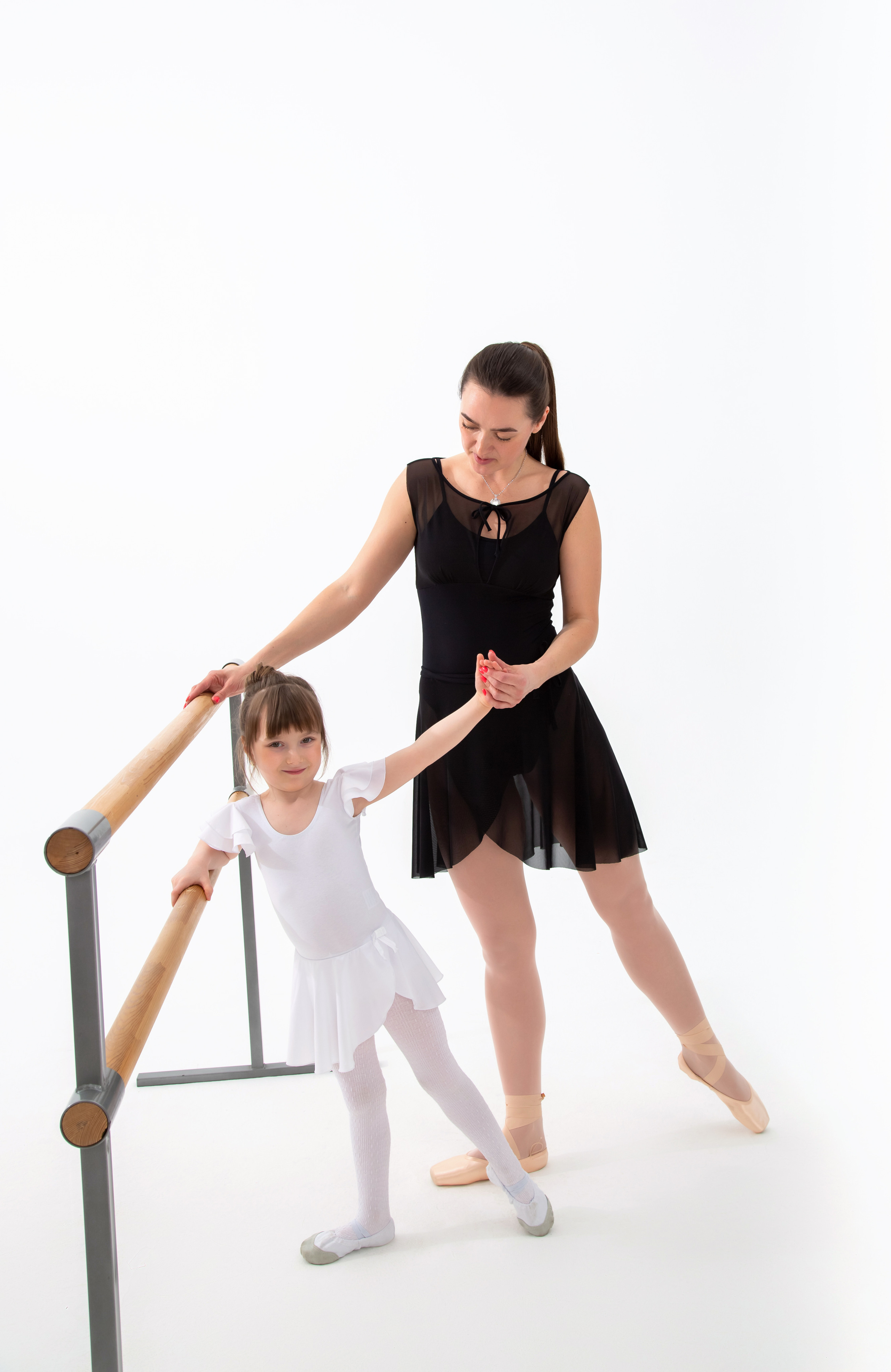 Девочка балерина позирует у станка вместе со своей мамой  на фотосессии для гимнастики и балета 