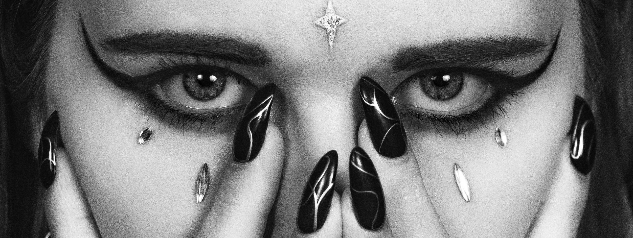 Черно-белое изображение девушки, которая прячет лицо руками