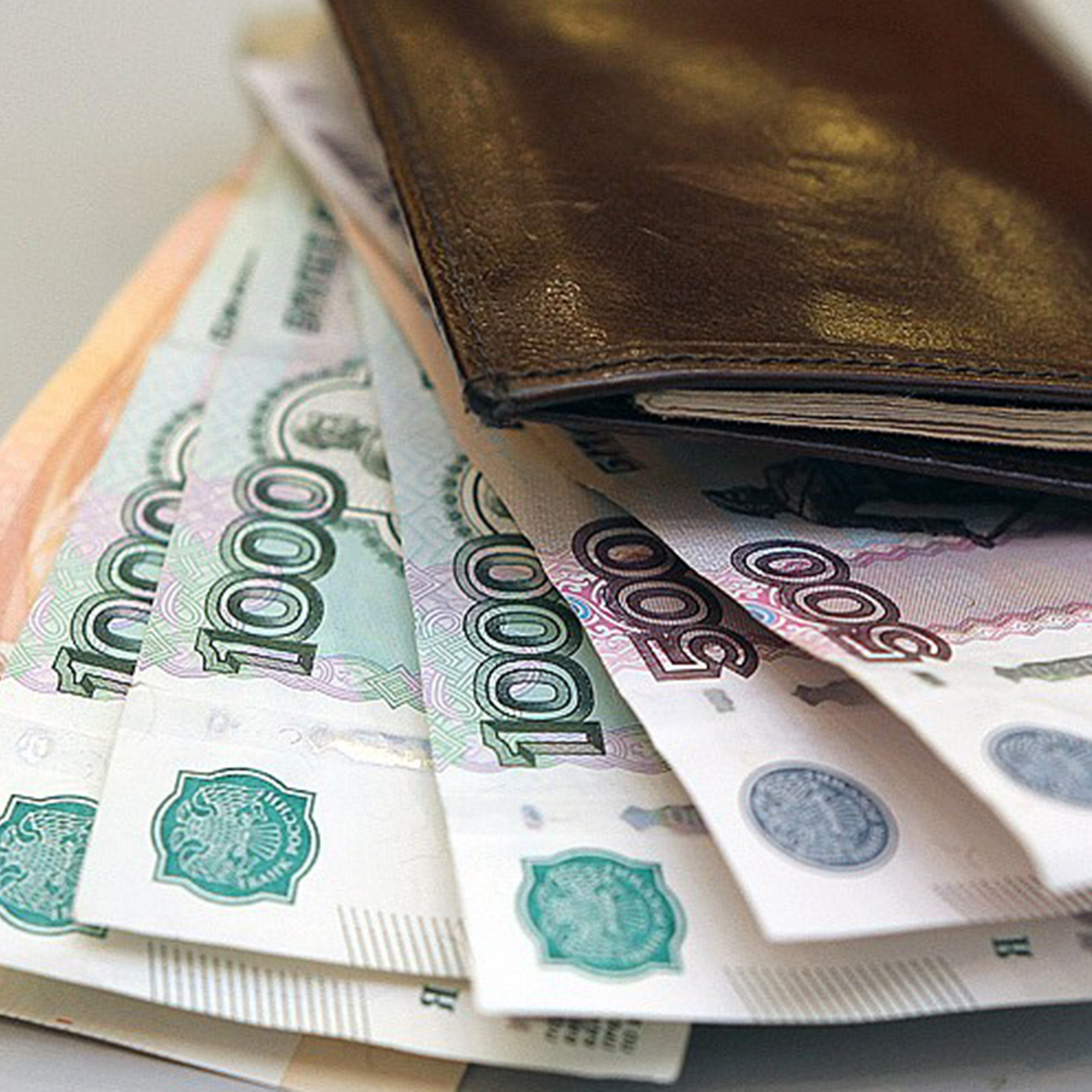 кошелек коричневого цвета с купюрами 500, 1000, 5000 руб.