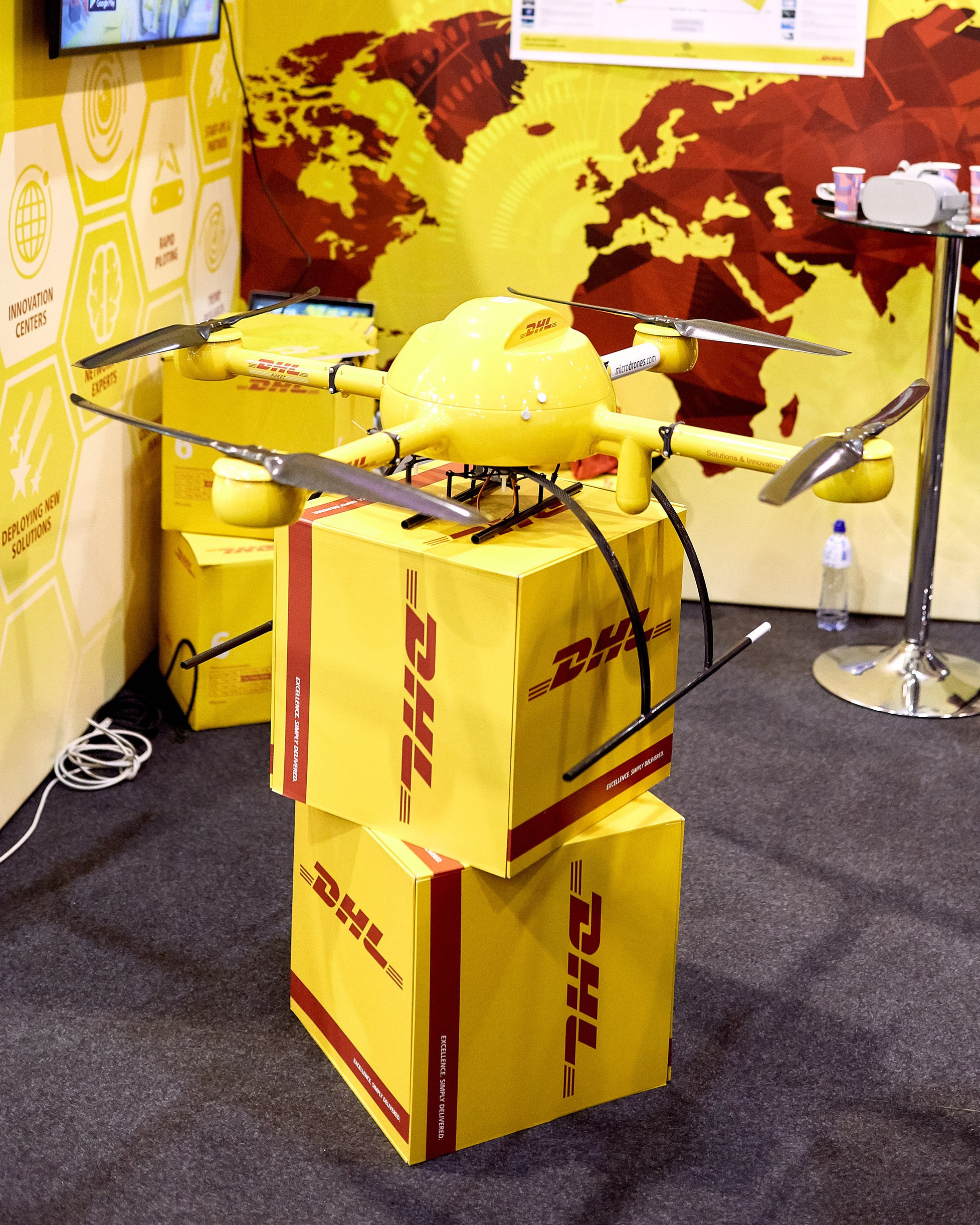 На выставке фотограф снимает стенд DHL – на кадре дрон для доставки