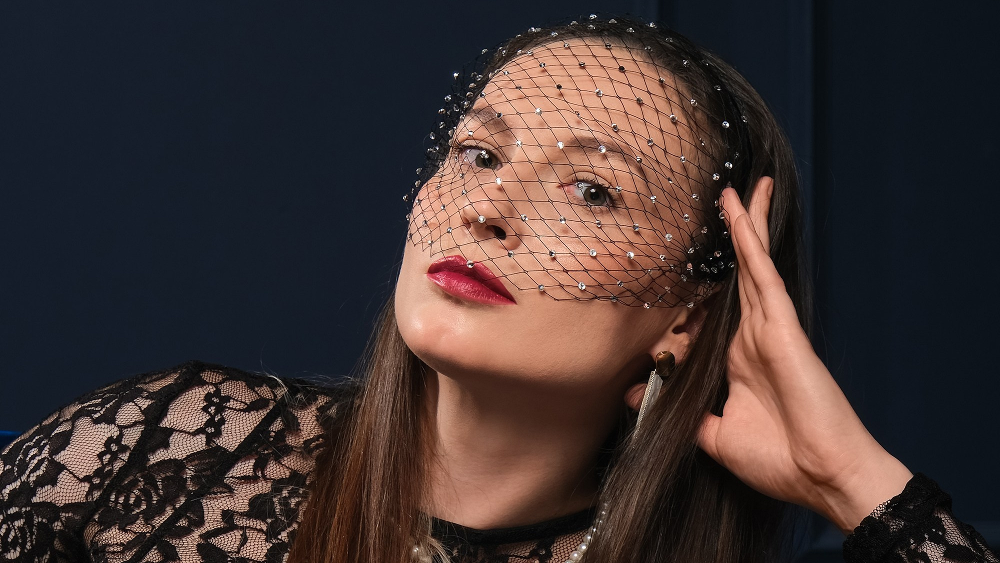 Фотограф Краснодар: девушка на синем фоне сидит на диване в красивом кружевном платье