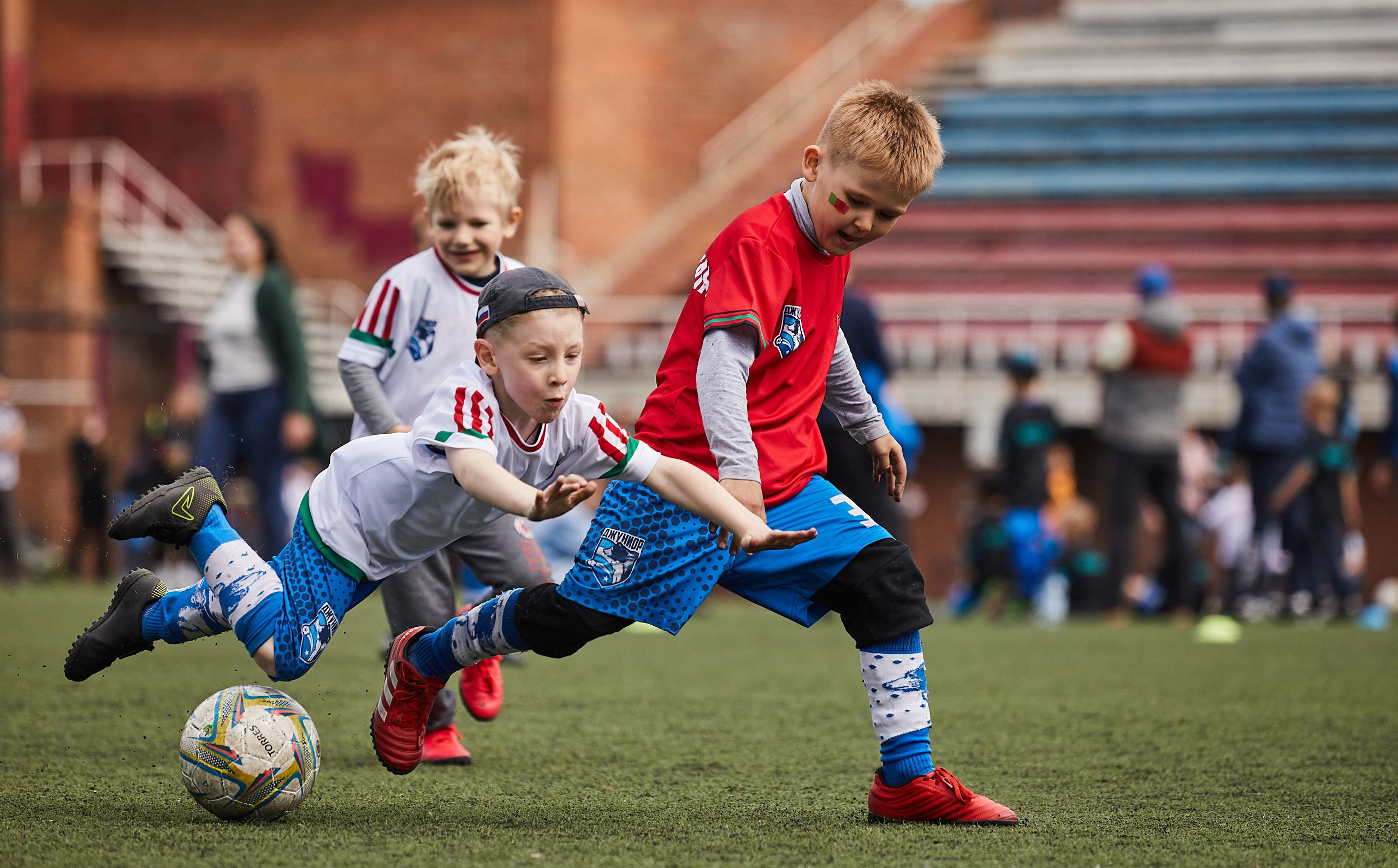 Дети играют в футбол на стадионе