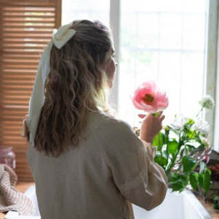 Девушка на даче ест томаты в легком платье