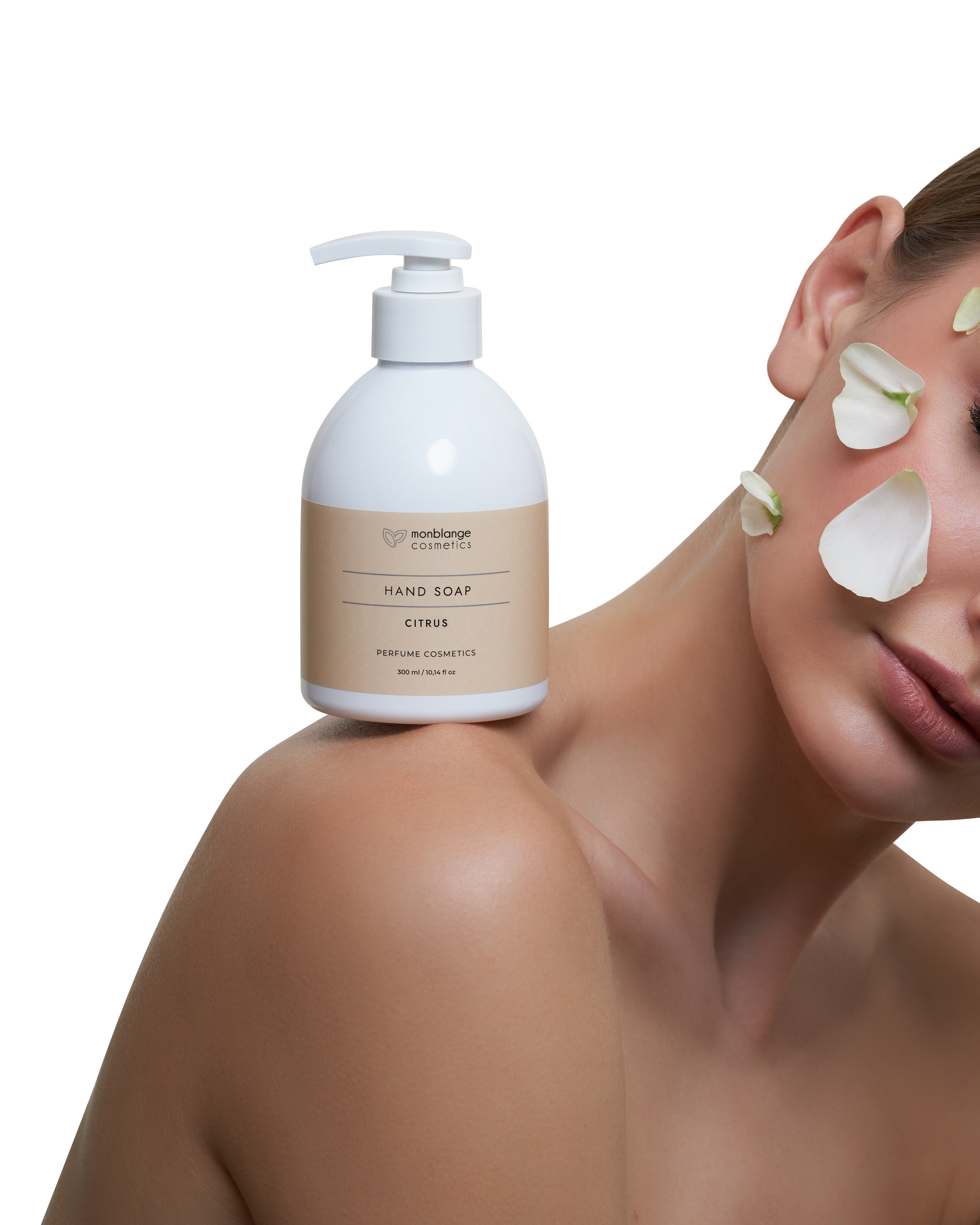 Банка мыла для рук стоит на плече у девушки, на лице которой белые лепестки цветов