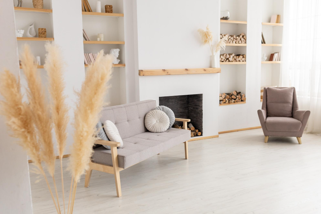 серые диван и кресло с белым камином в светлой студии