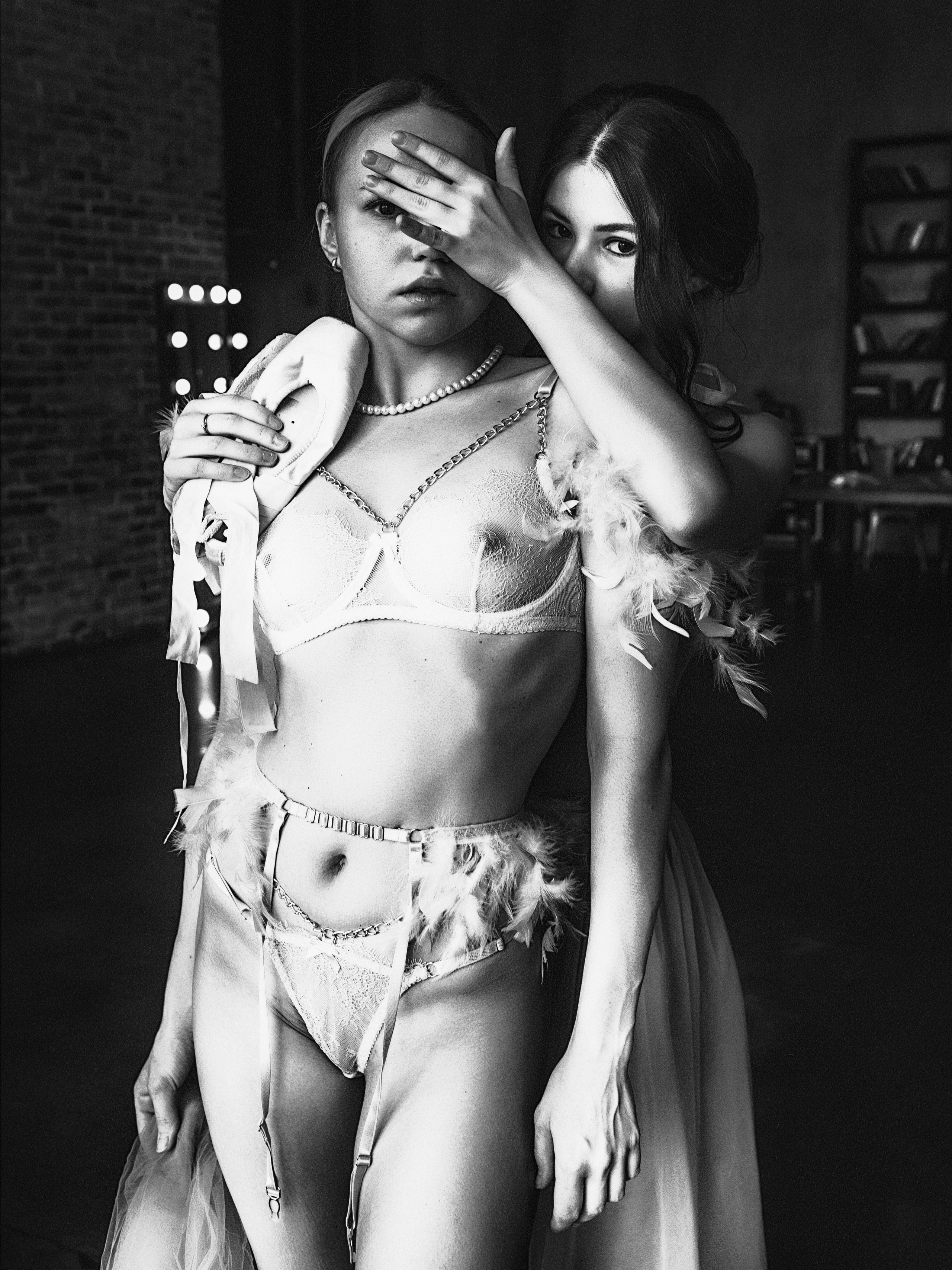 Девушки в винтажном нижнем белье прикрывают друг другу глаза.