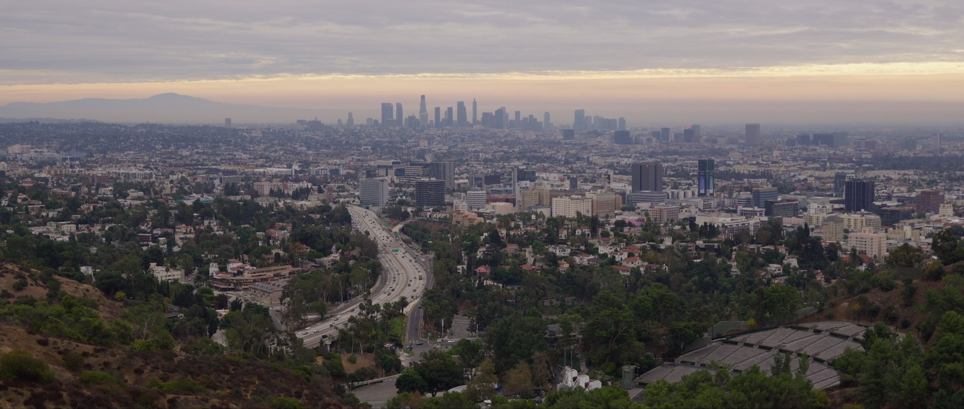 Panoramic view of Los Angeles skyline under a cloudy sky, capturing the city’s dynamic atmosphere and creative energy for fashion film production.