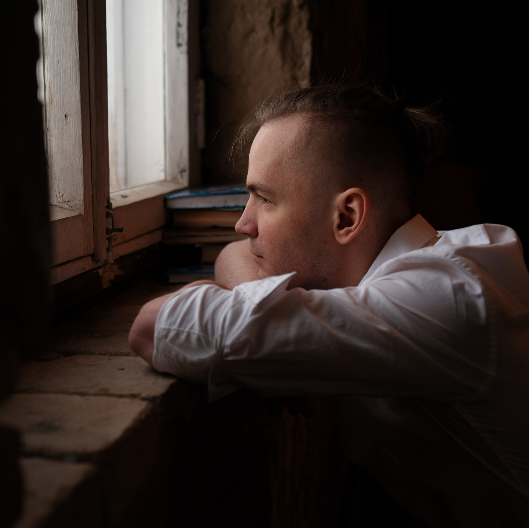 Фото задумчивого парня у окна.