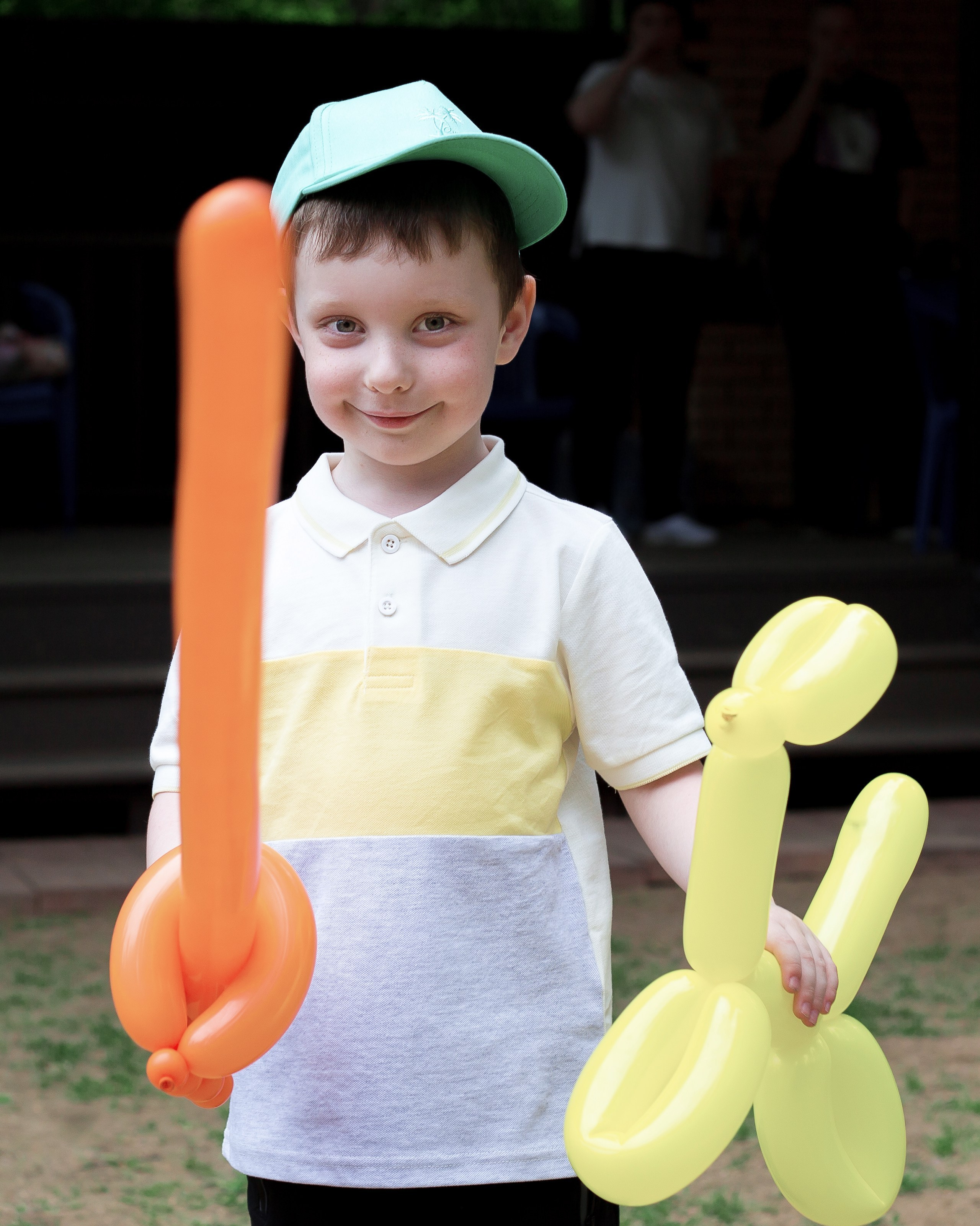 Мальчик на улице с надувным мечом и надувной собачкой