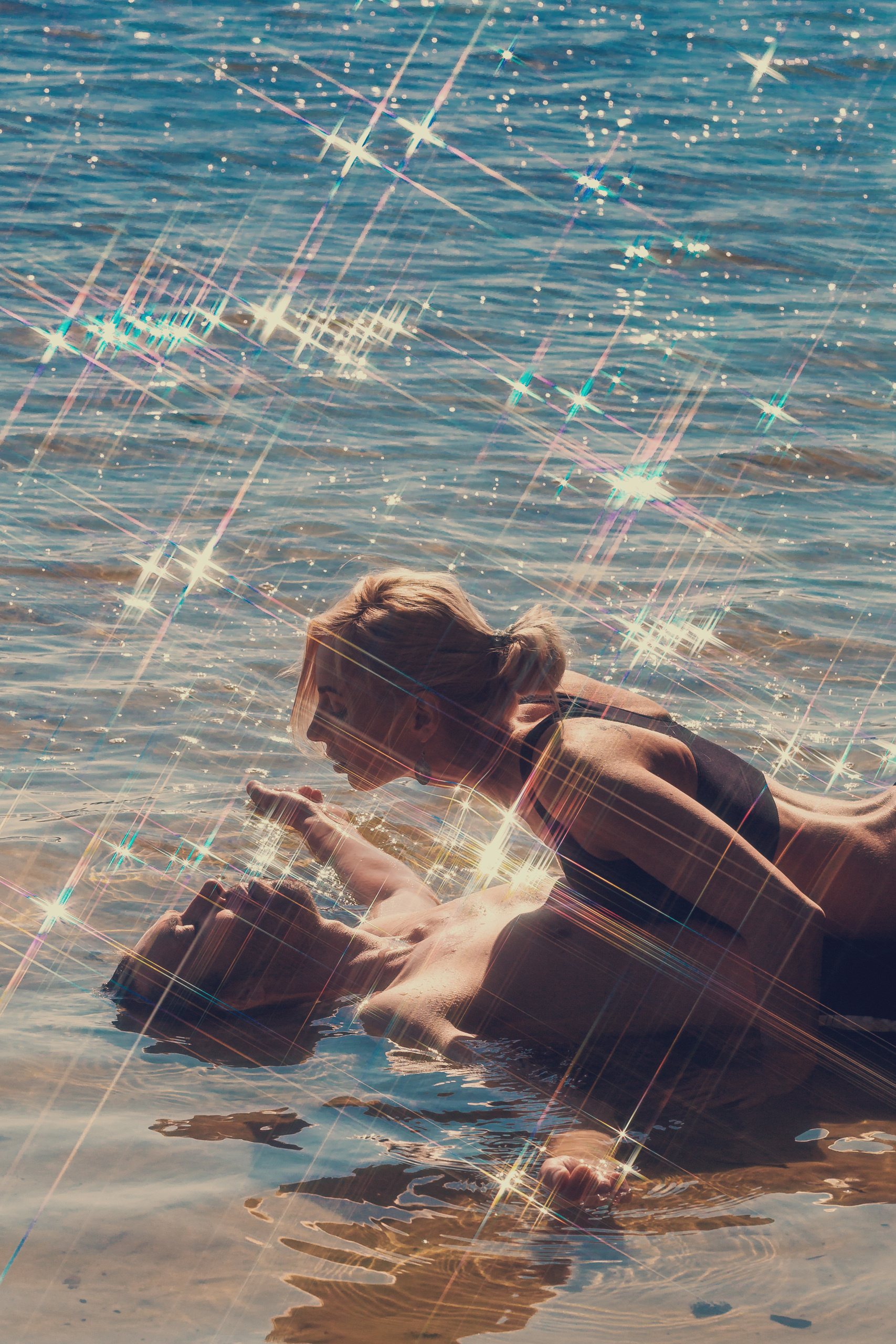 парень лежит в воде, девушка на нем