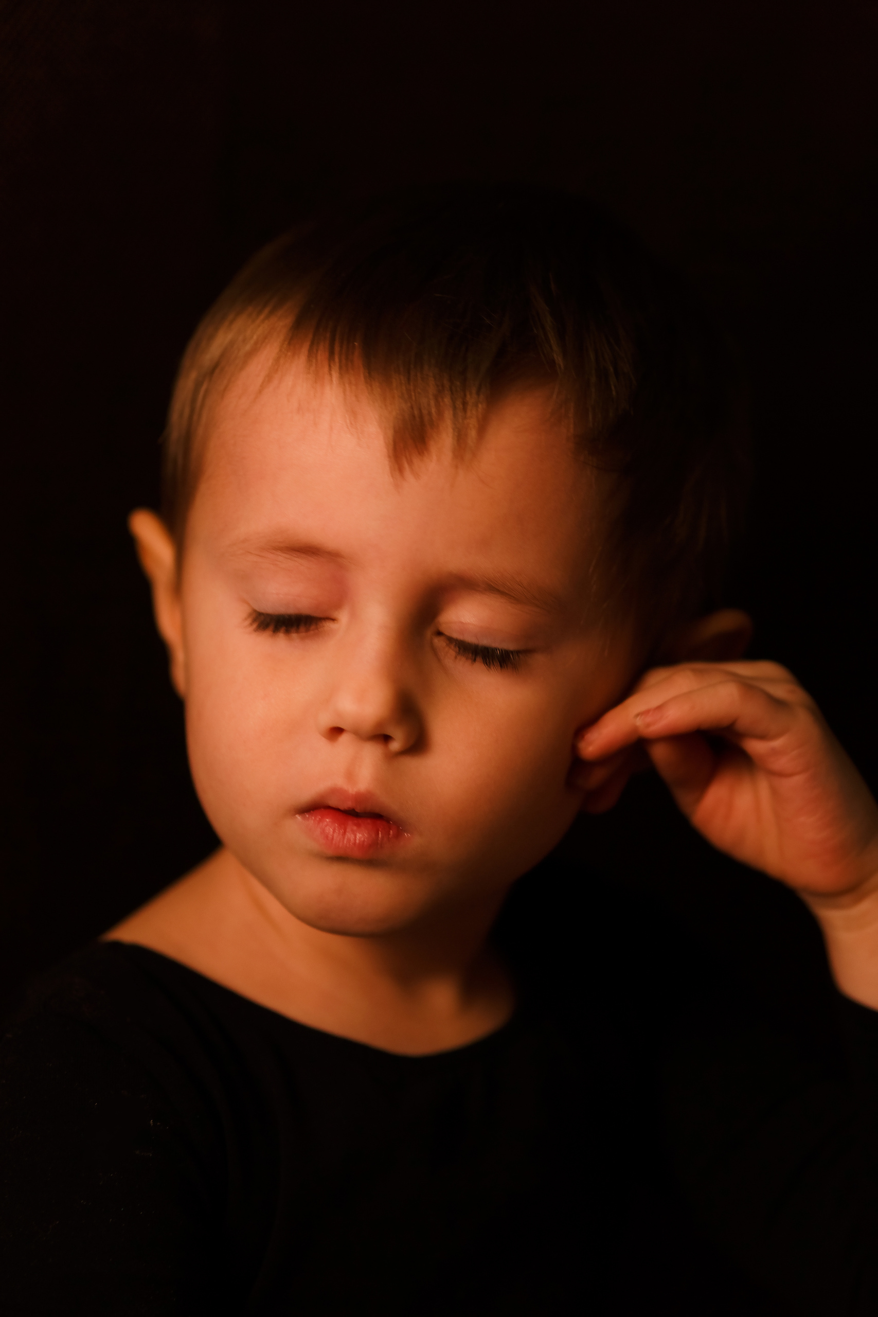 Портрет маленькой девочки в черном гимнастическом купальнике на черном фоне на детской фотосессии от фотографа Галины Шараповой