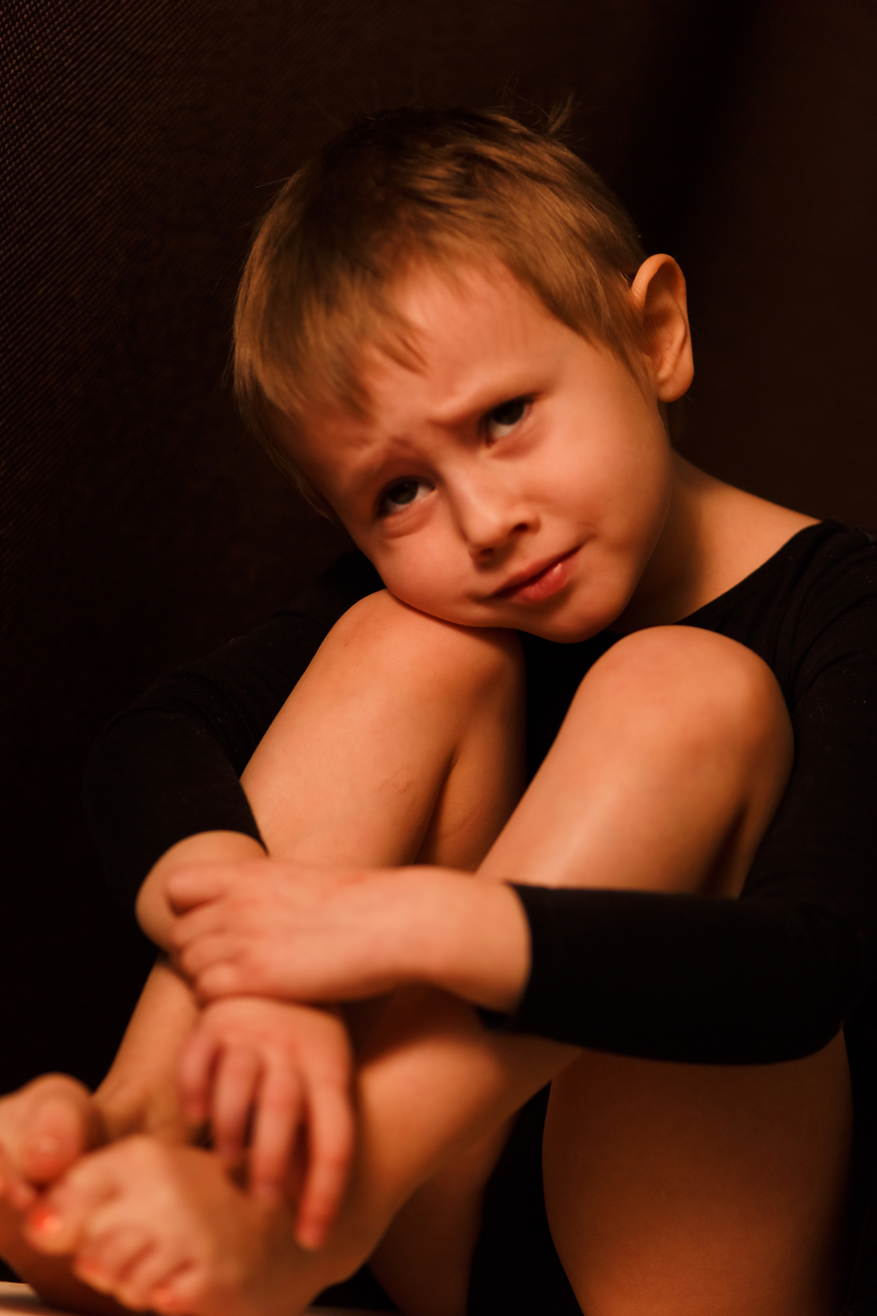Портрет маленькой девочки в черном гимнастическом купальнике на черном фоне на детской фотосессии от фотографа Галины Шараповой