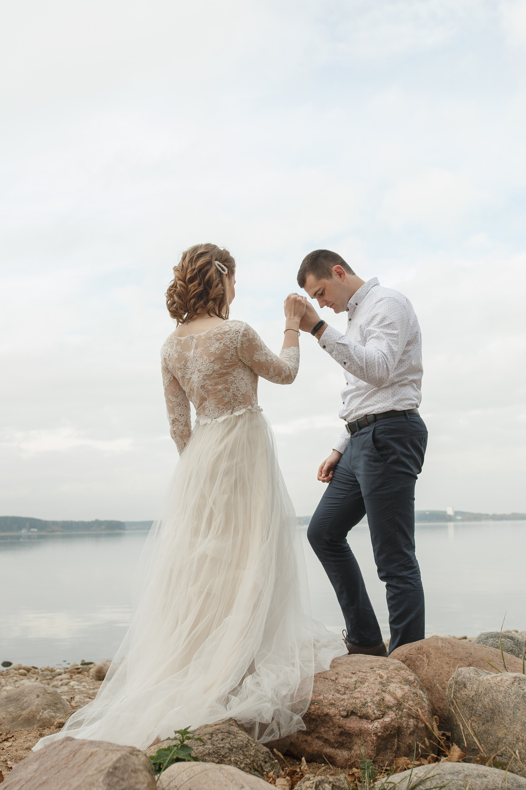 Свадебная прогулка красивой пары на берегу озера