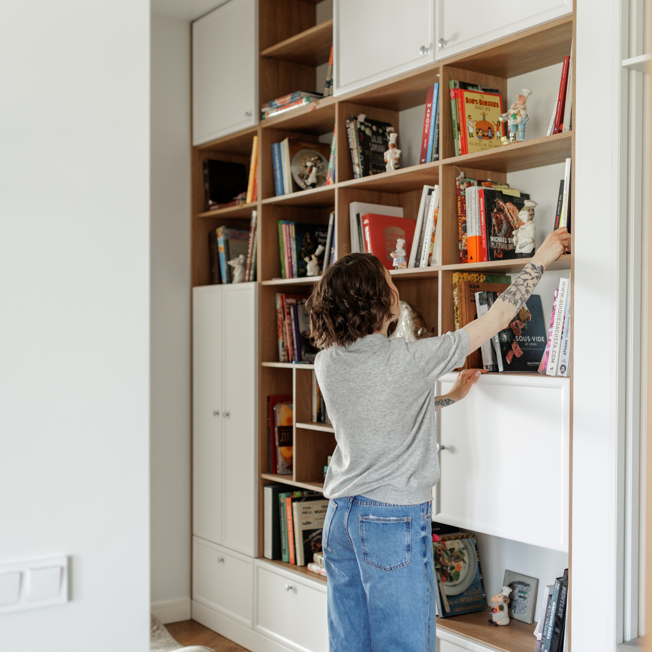 Фуд стилист берет с книжной полки кулинарную книгу
