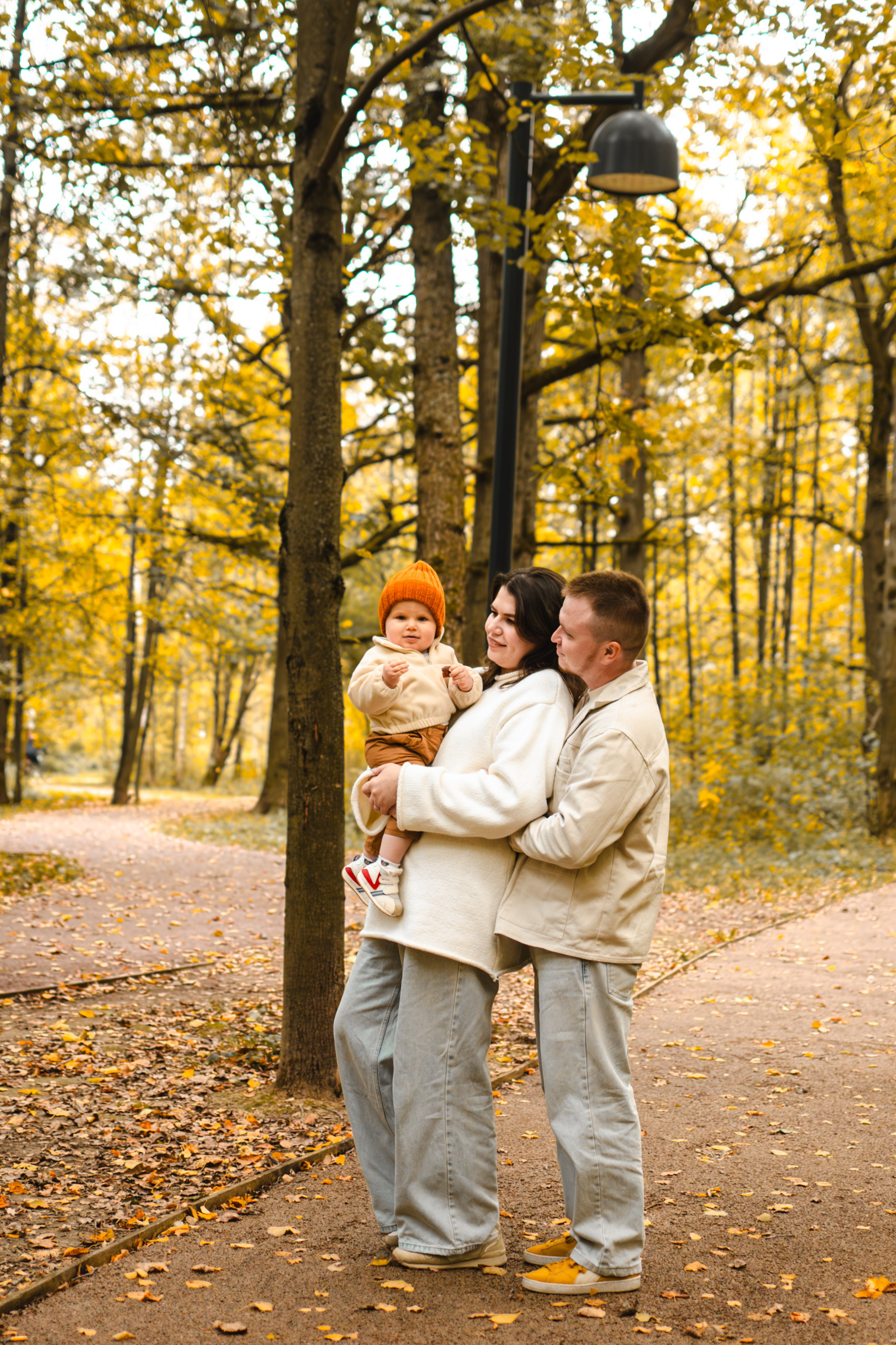 Полный кадр семьи, идущей по аллее с осенними деревьями, уличная съёмка, 