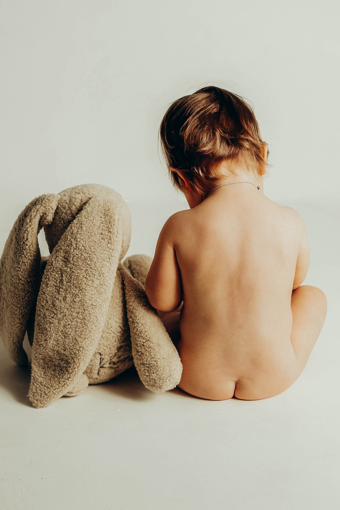 Годовалый малыш с мишкой в процессе фотосессии